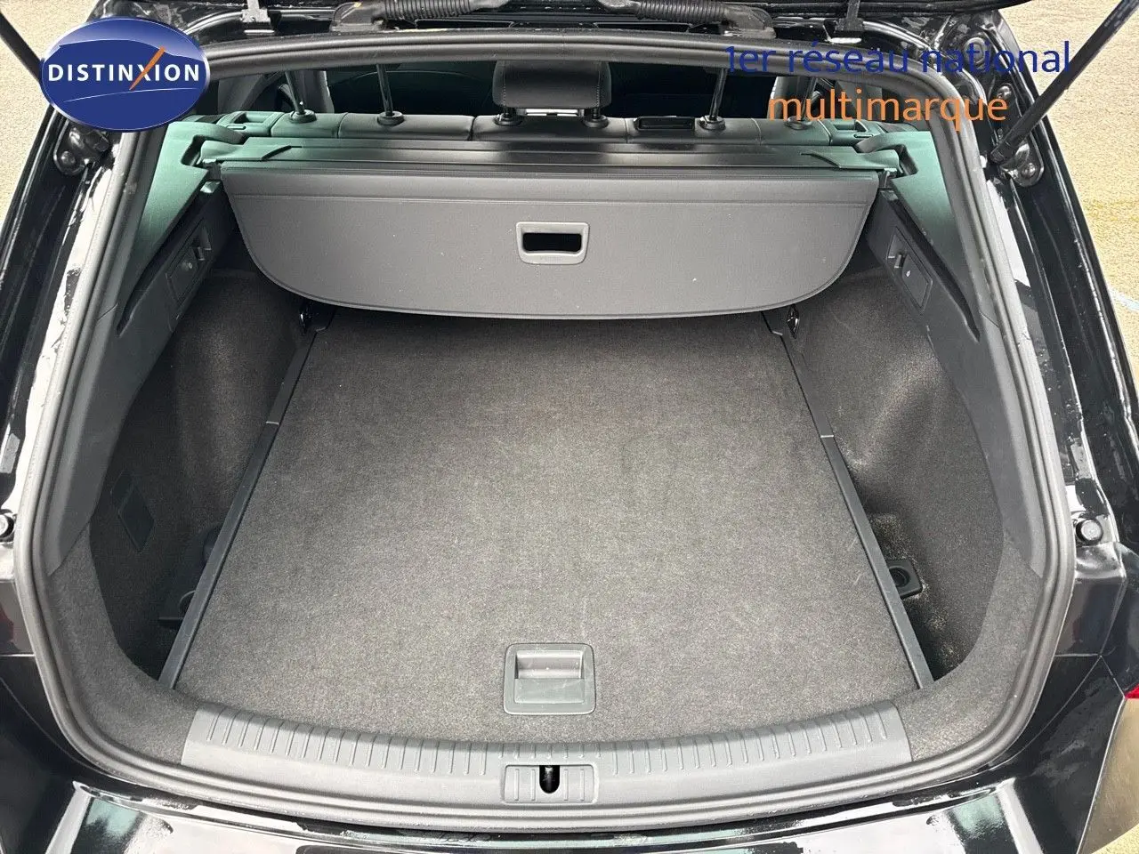 Coffre ouvert vu de l'arrière d'une CUPRA LEON ST noire Midnight Metal, montrant un espace de chargement propre et spacieux.