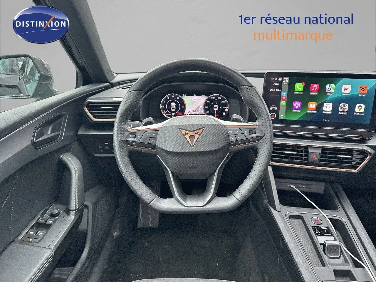Vue intérieure du poste de conduite de la CUPRA LEON ST 2024 avec volant multifonction et écran tactile central lumineux.
