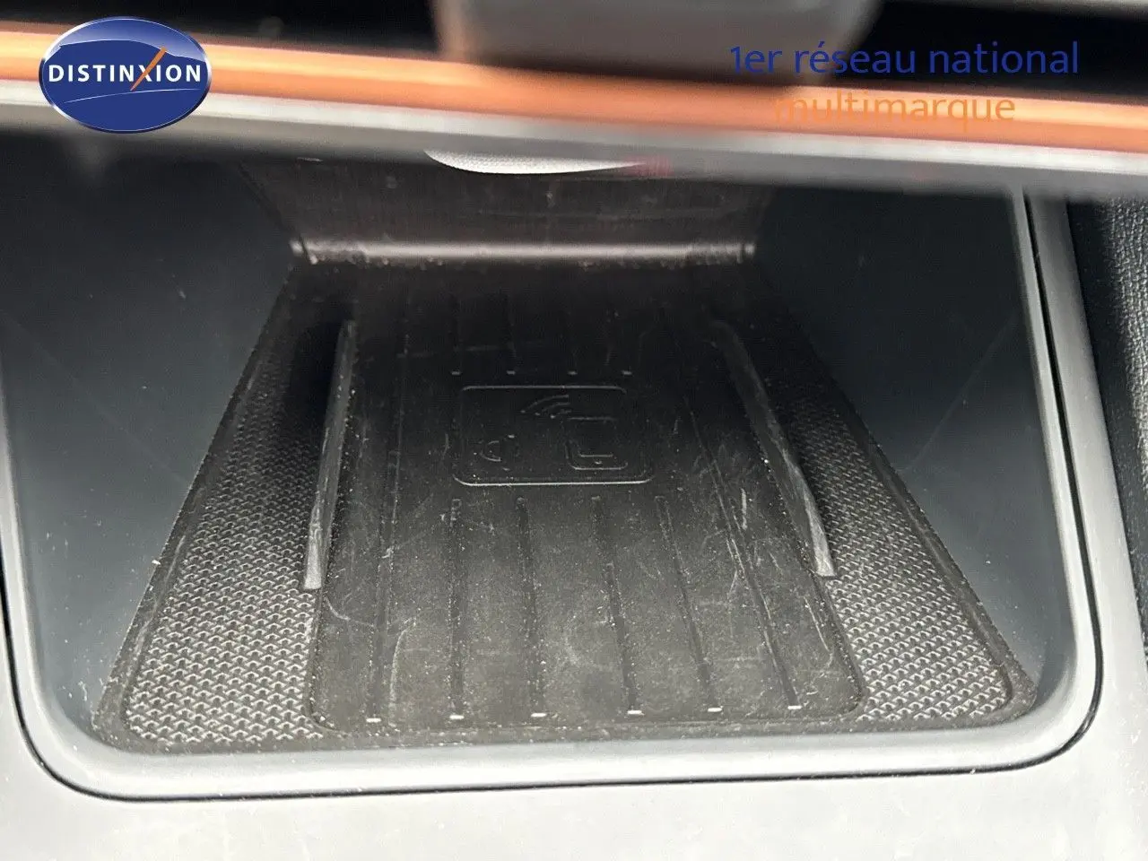 Surface de recharge sans fil noire dans l'habitacle d'une CUPRA LEON ST 2024, vue en gros plan.