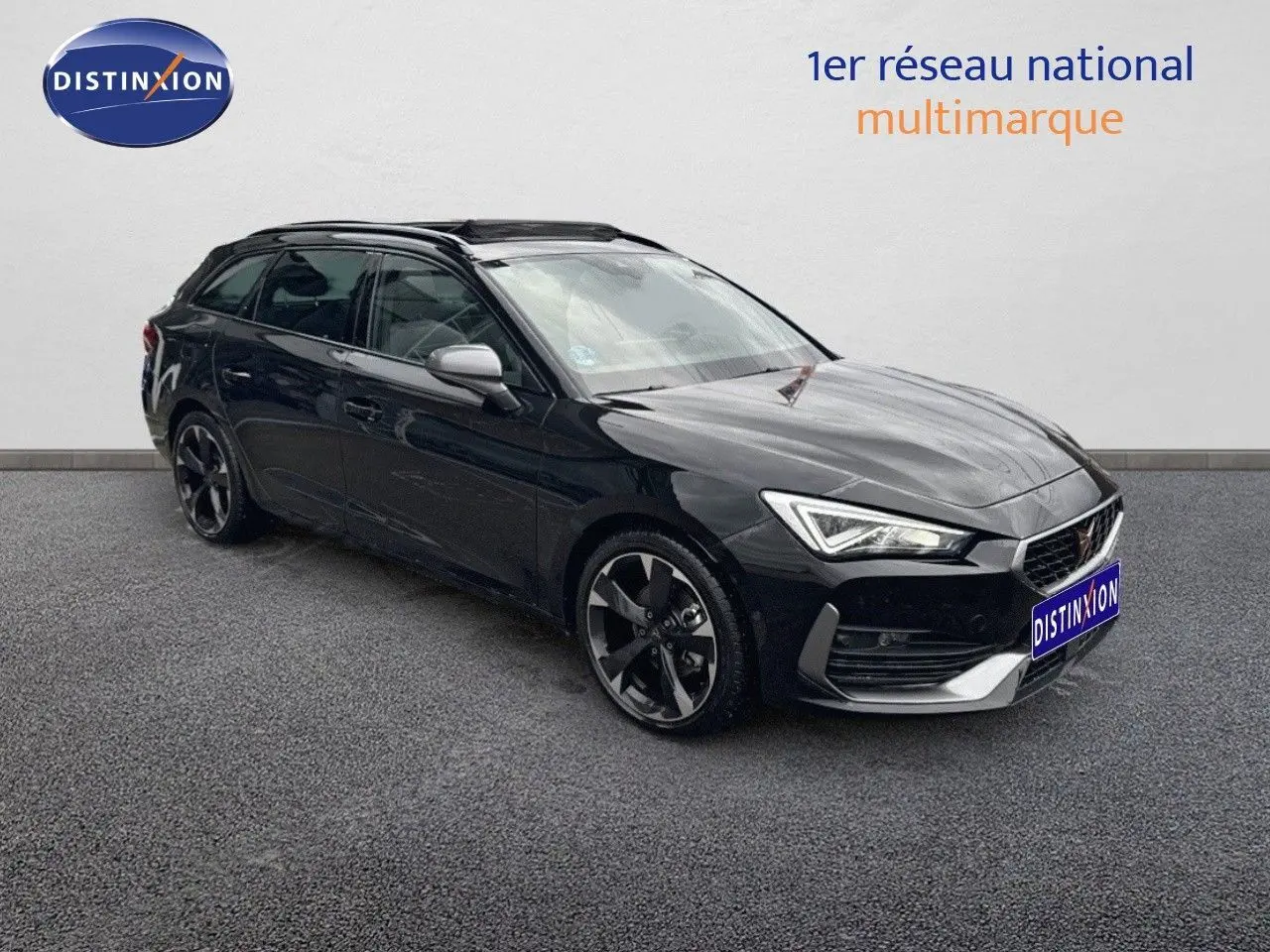 Vue 3/4 avant d'une CUPRA LEON ST 1.5 ETSI noire Midnight Metal avec jantes biton et phares LED allumés.