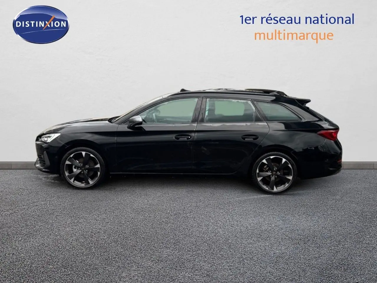 Profil latéral gauche d'une CUPRA LEON ST 1.5 ETSI 150CH DSG noire Midnight Metal avec jantes bi-ton élégantes.