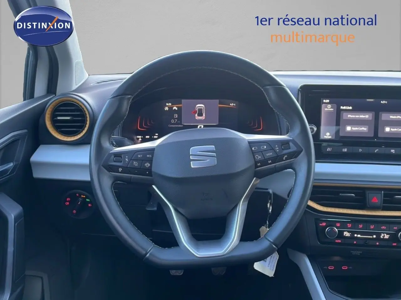 Vue intérieure centrée sur le volant cuir noir et le tableau de bord numérique du SEAT Arona blanc toit gris 2025.