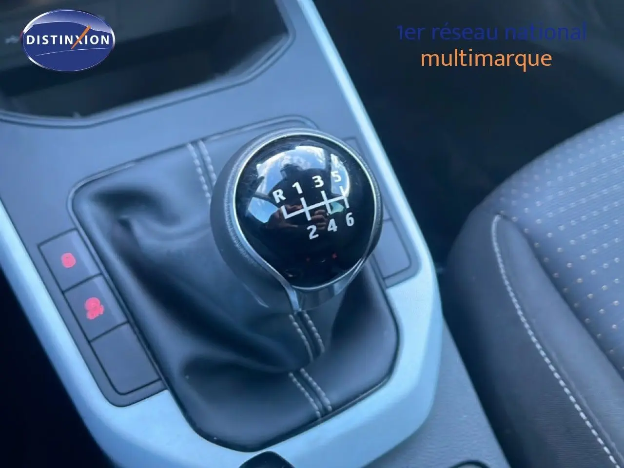 Gros plan sur le levier de vitesses manuel noir avec coutures blanches dans l'habitacle d'une SEAT Arona 2025.