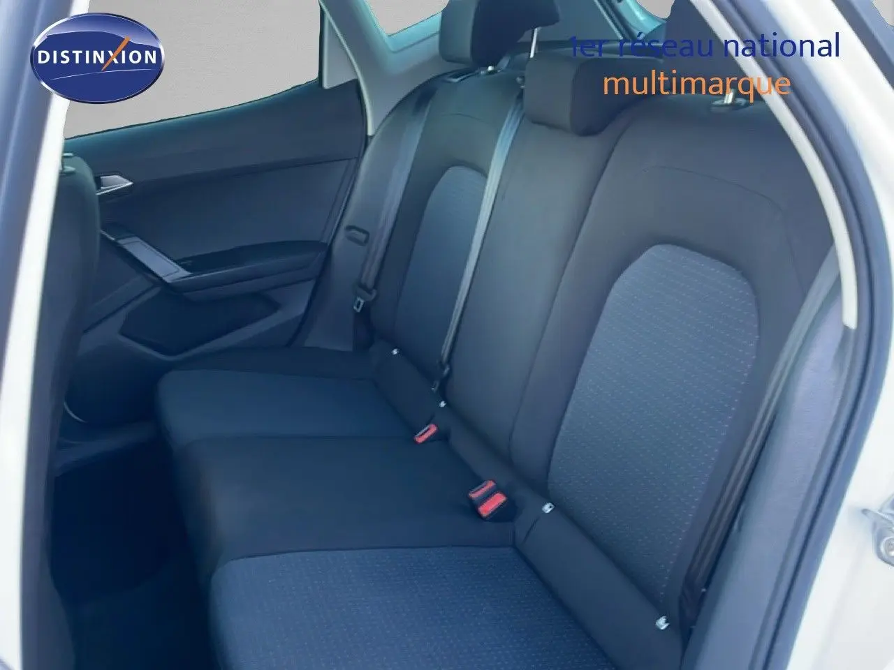 Vue intérieure côté arrière droit montrant les sièges arrière en tissu noir avec détails gris sur un SEAT Arona blanc.