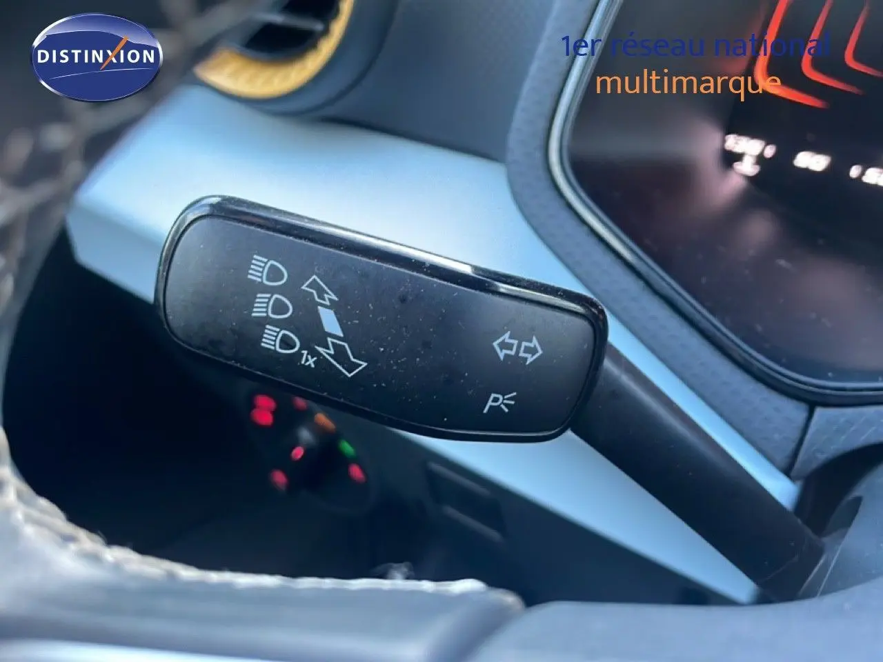 Gros plan sur la manette de clignotant à gauche du volant dans l’habitacle du SEAT Arona blanc toit gris.