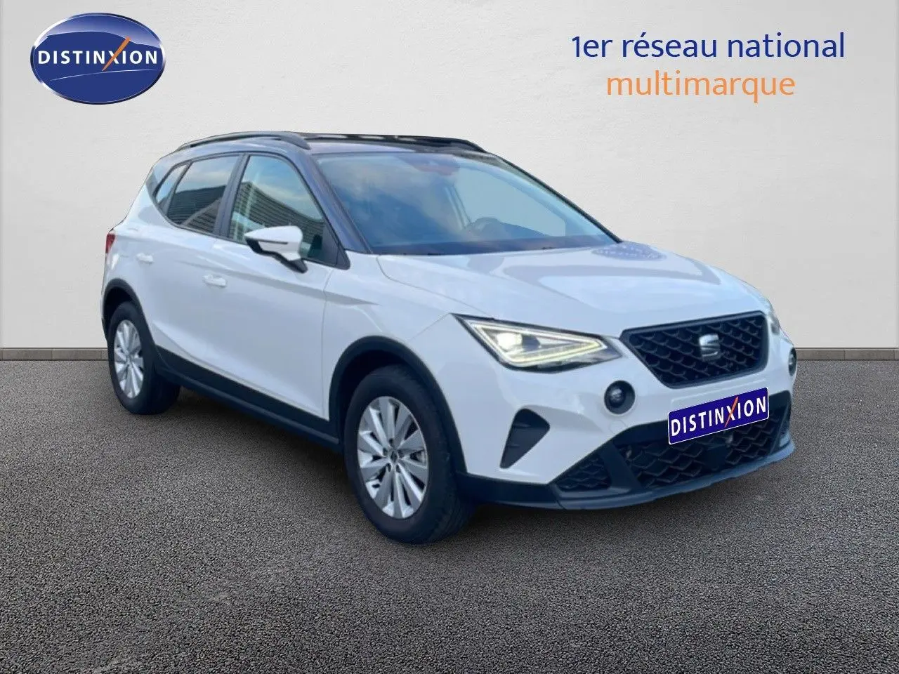SEAT Arona blanc avec toit gris, vue 3/4 avant droit, phares allumés et calandre noire distinctive.