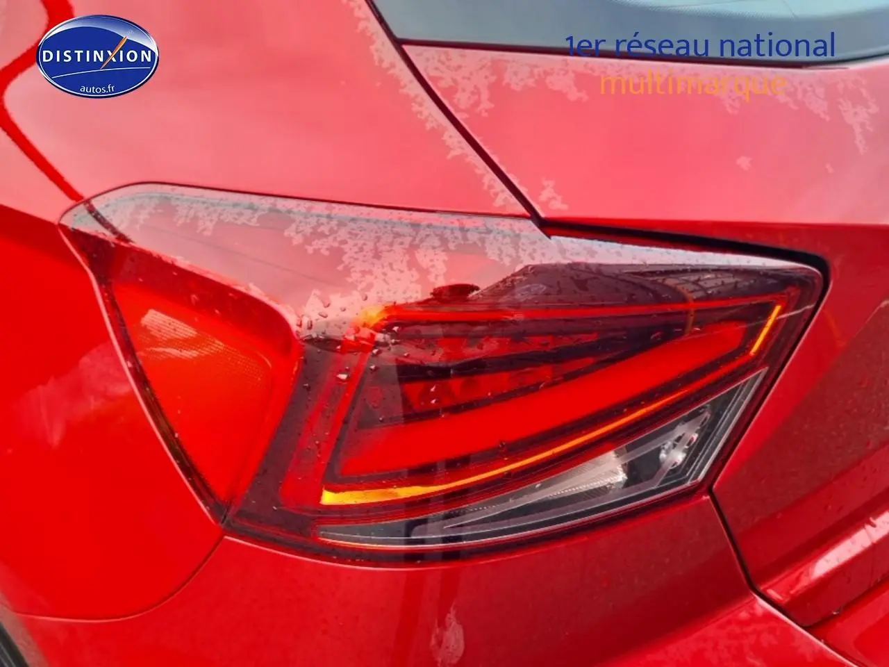 Gros plan sur le feu arrière droit rouge d’une SEAT Ibiza 1.0 TSI 95 Copa rouge désir 2025, carrosserie mouillée.