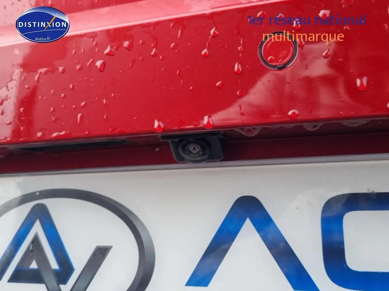 Gros plan sur la caméra de recul et le capteur de stationnement arrière d'une SEAT Ibiza rouge désir, hayon humide.