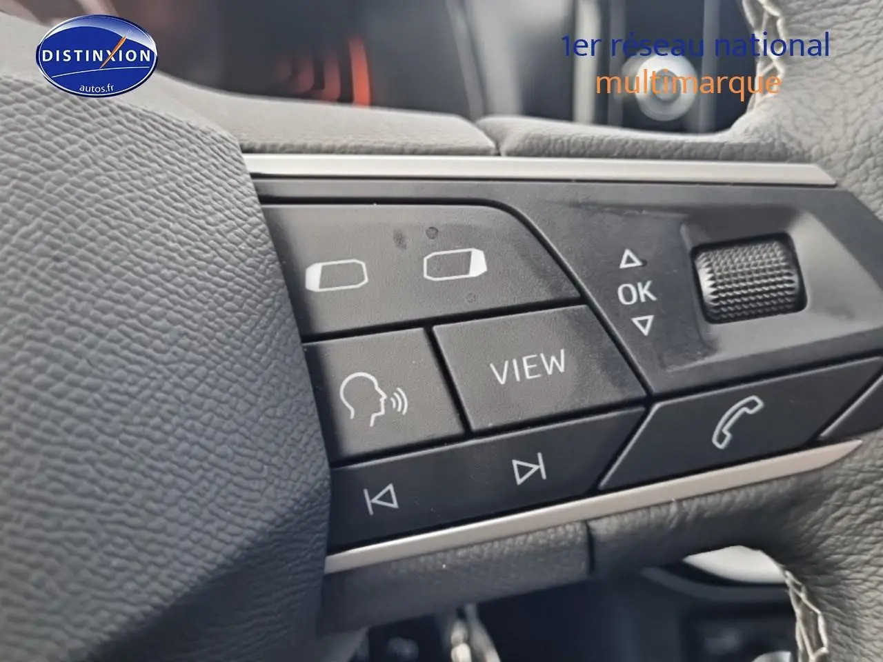Gros plan sur les commandes multifonctions noires du volant cuir du SEAT Ibiza 2025, avec boutons de navigation et appel.