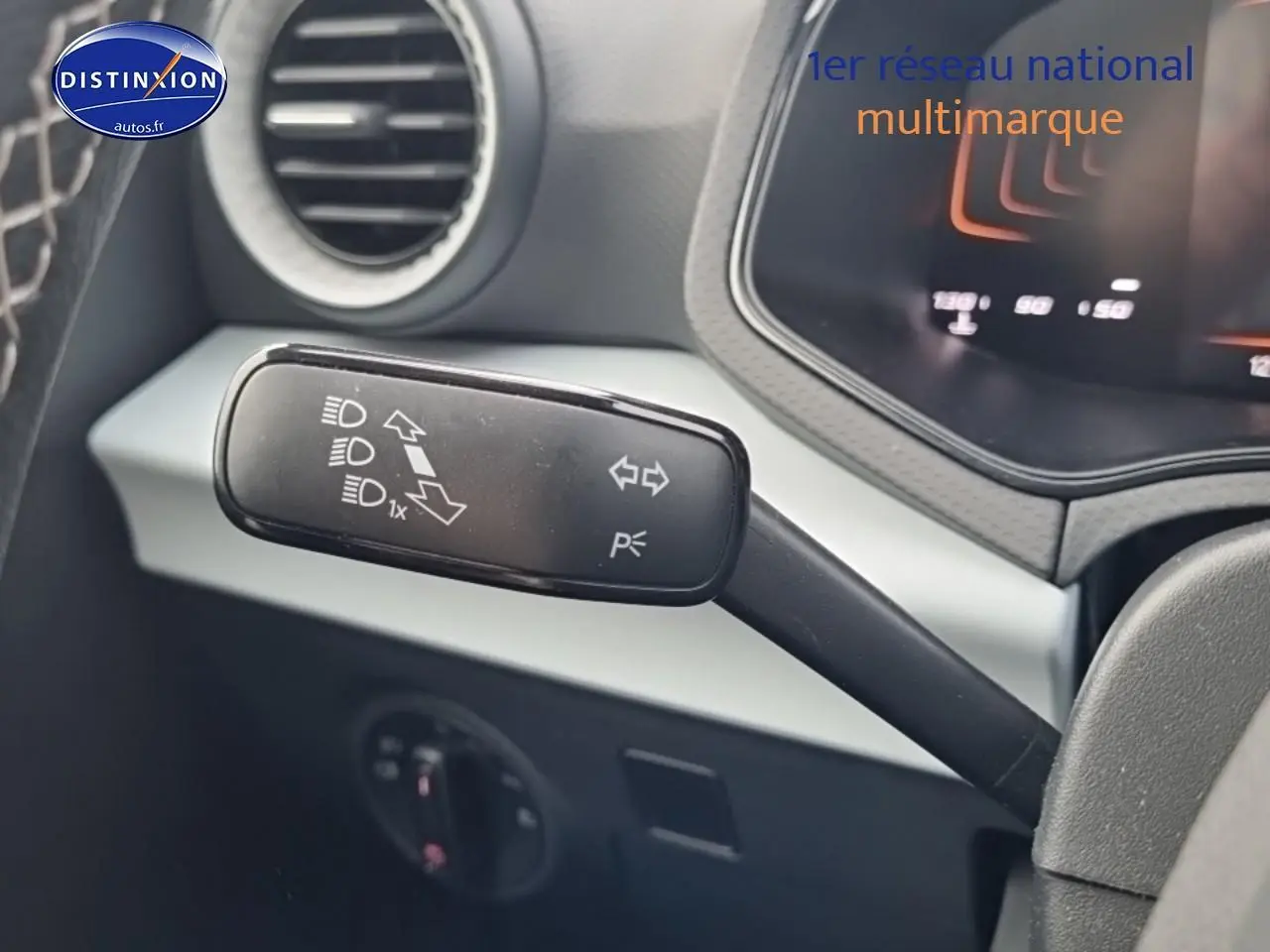 Gros plan sur la manette de clignotant à gauche du volant d'une SEAT Ibiza 2025 rouge désir, intérieur gris.