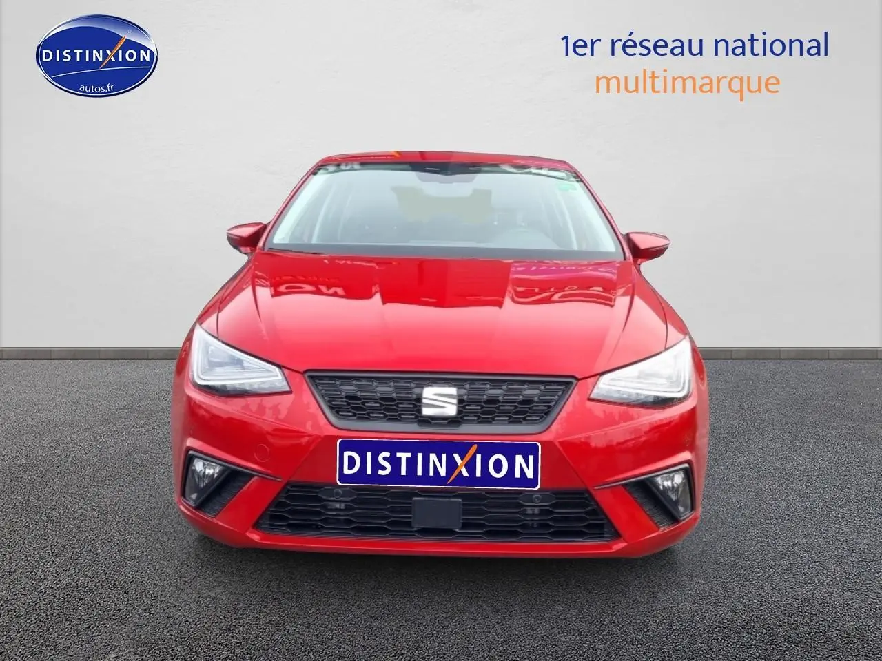 Vue frontale d'une SEAT Ibiza rouge désir 2025 avec calandre noire et phares LED triangulaires.