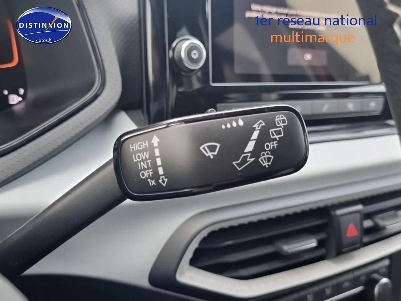 Gros plan sur la commande d’essuie-glace dans l’habitacle gris clair de la SEAT Ibiza 2025 rouge désir.