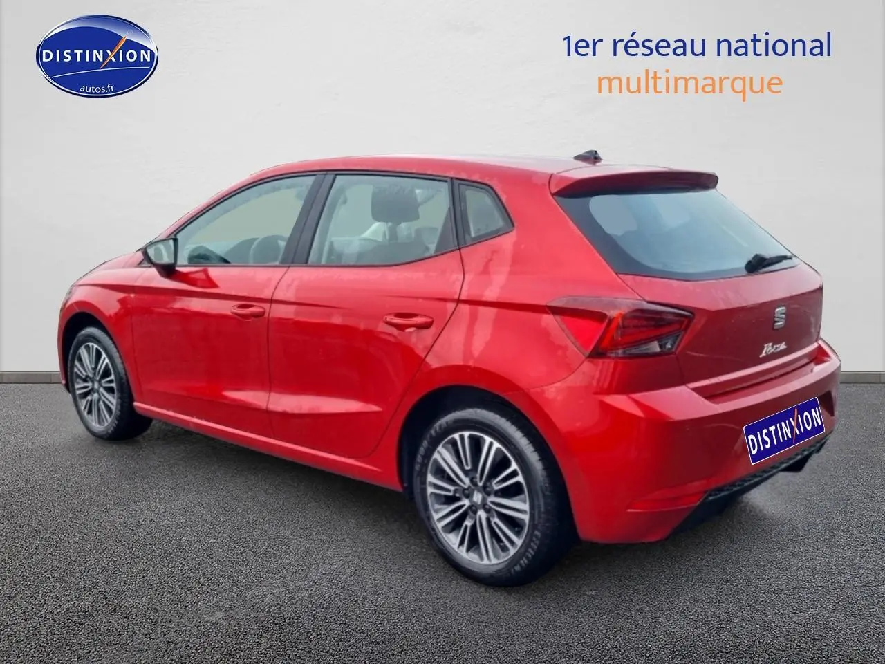 Vue 3/4 arrière droite d'une SEAT Ibiza rouge désir avec jantes alliage et feux arrière LED distinctifs.
