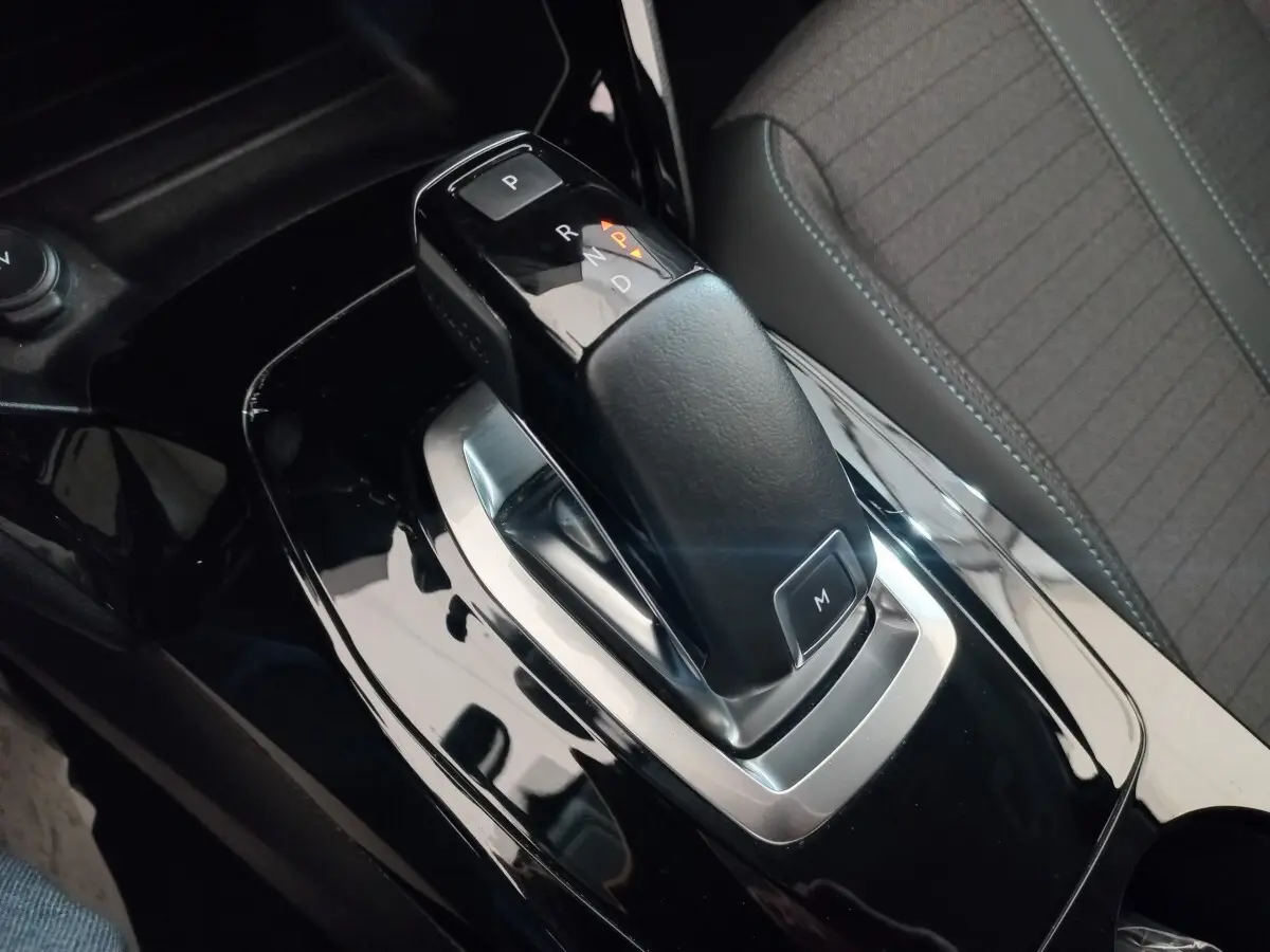 Le levier de vitesse automatique noir de la Peugeot 208 PureTech 100 vu en gros plan intérieur côté conducteur.