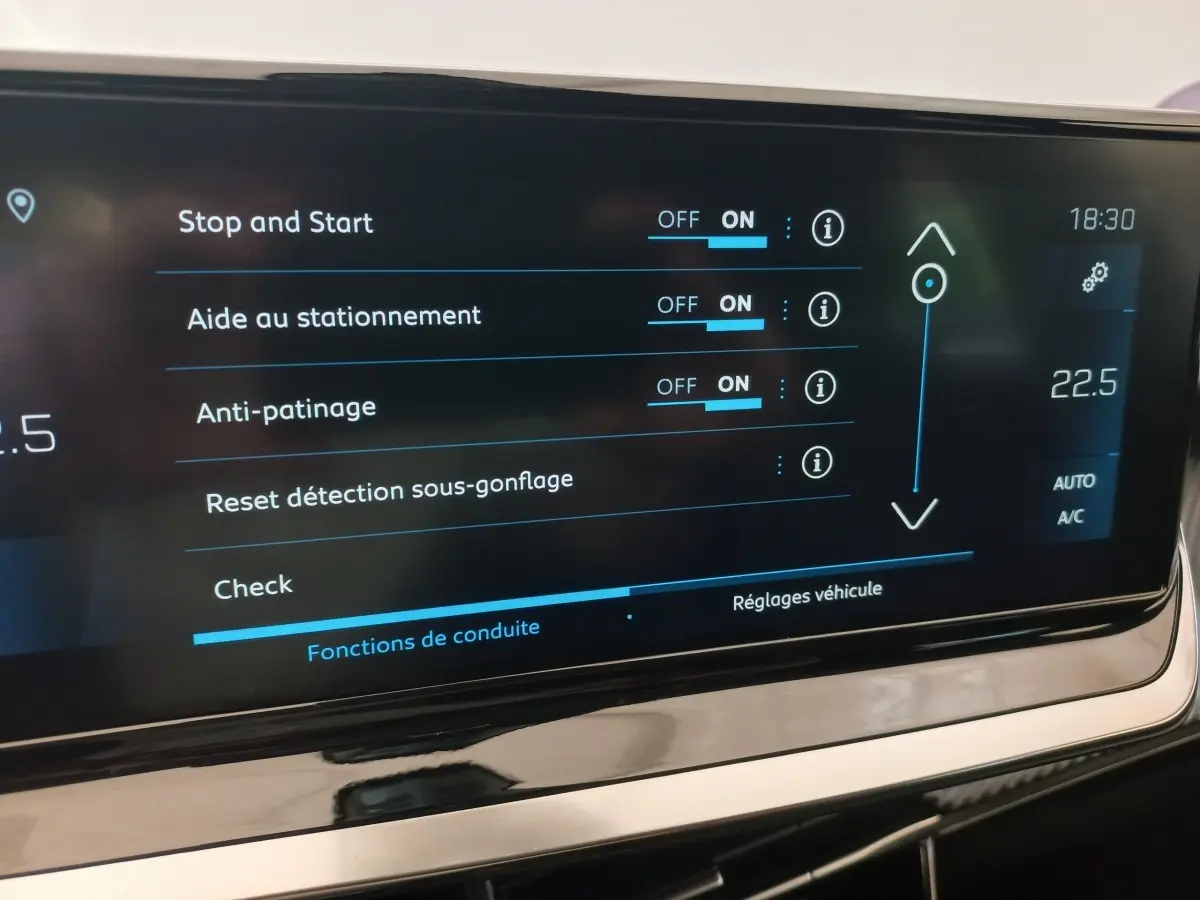 Écran tactile central affichant les réglages d’aide à la conduite dans une Peugeot 208 noire, vue intérieure rapprochée.