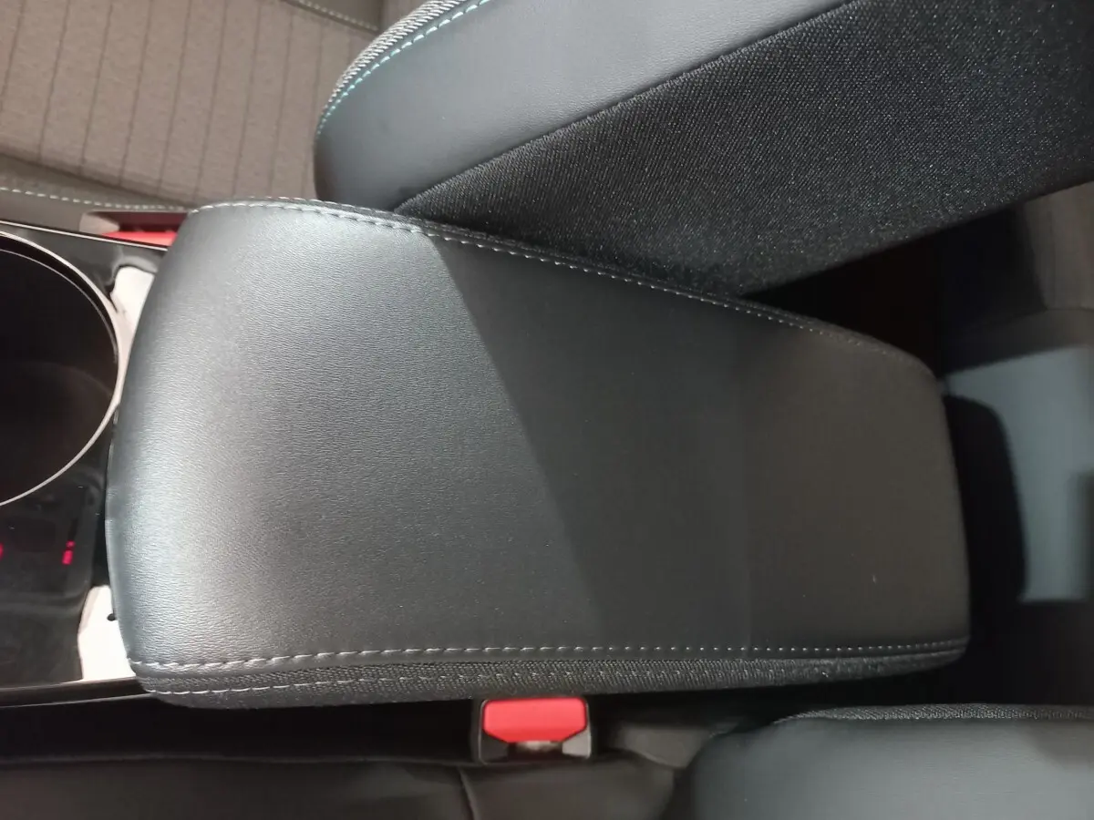 Détail de l'accoudoir central noir en cuir avec surpiqûres, intérieur de la Peugeot 208 PureTech 100 Allure Pack 2022.