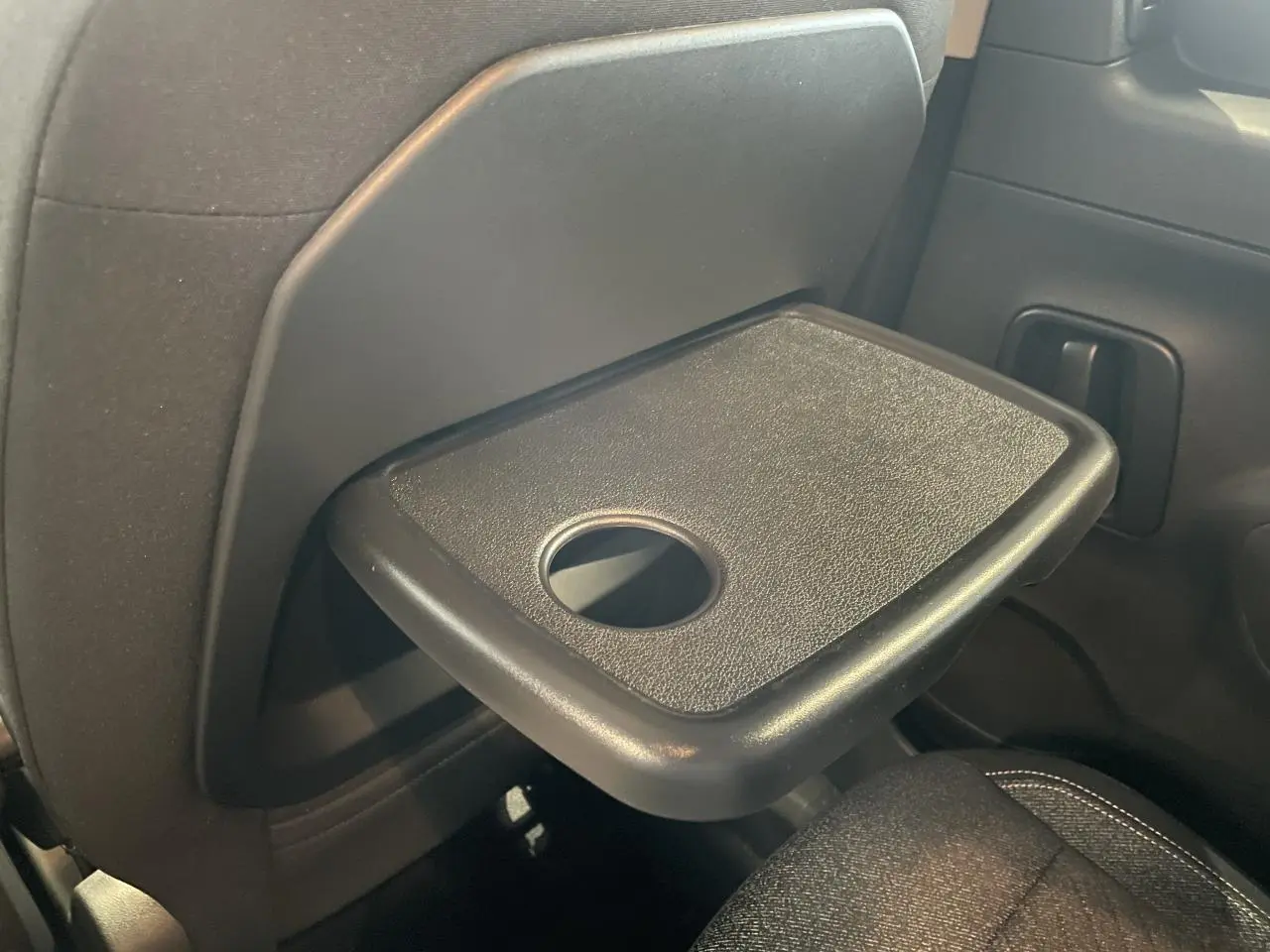 Tablette aviation déployée côté droit à l'arrière d'un Peugeot Rifter gris Artense, vue intérieure rapprochée.