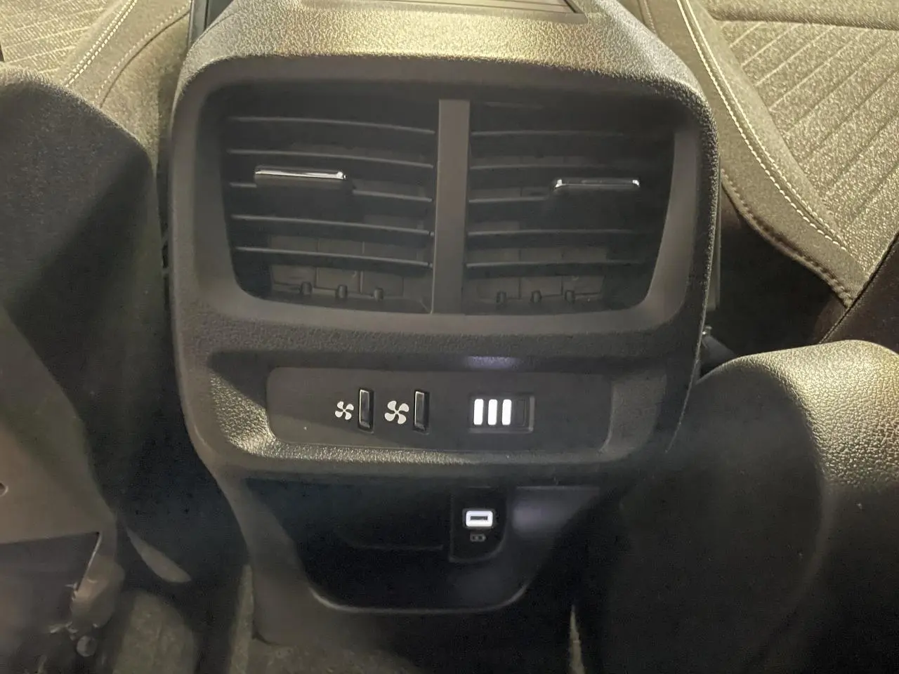 Détail de la console arrière du Peugeot Rifter gris Artense, montrant les aérateurs et commandes de ventilation avec ports USB.