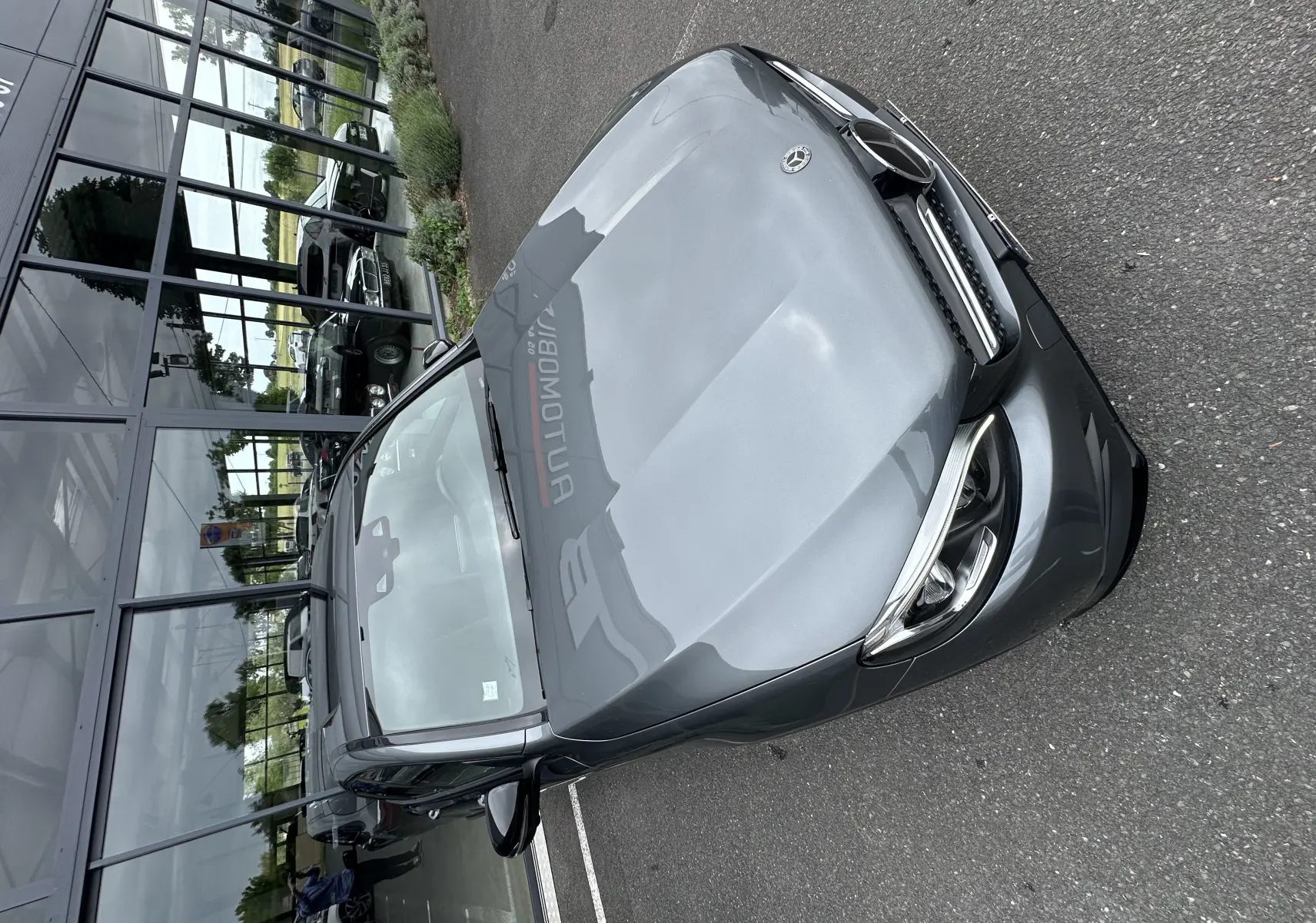 Mercedes GLC Coupé gris foncé vu de face en léger plongée, mettant en valeur ses phares LED et sa calandre distinctive.