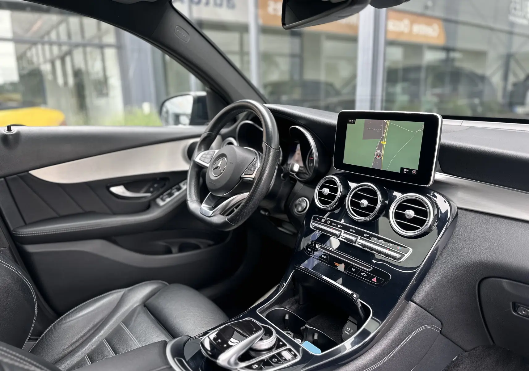 Intérieur du Mercedes GLC Coupé 250 D Fascination 2018, vue côté conducteur, tableau de bord noir avec écran GPS central.