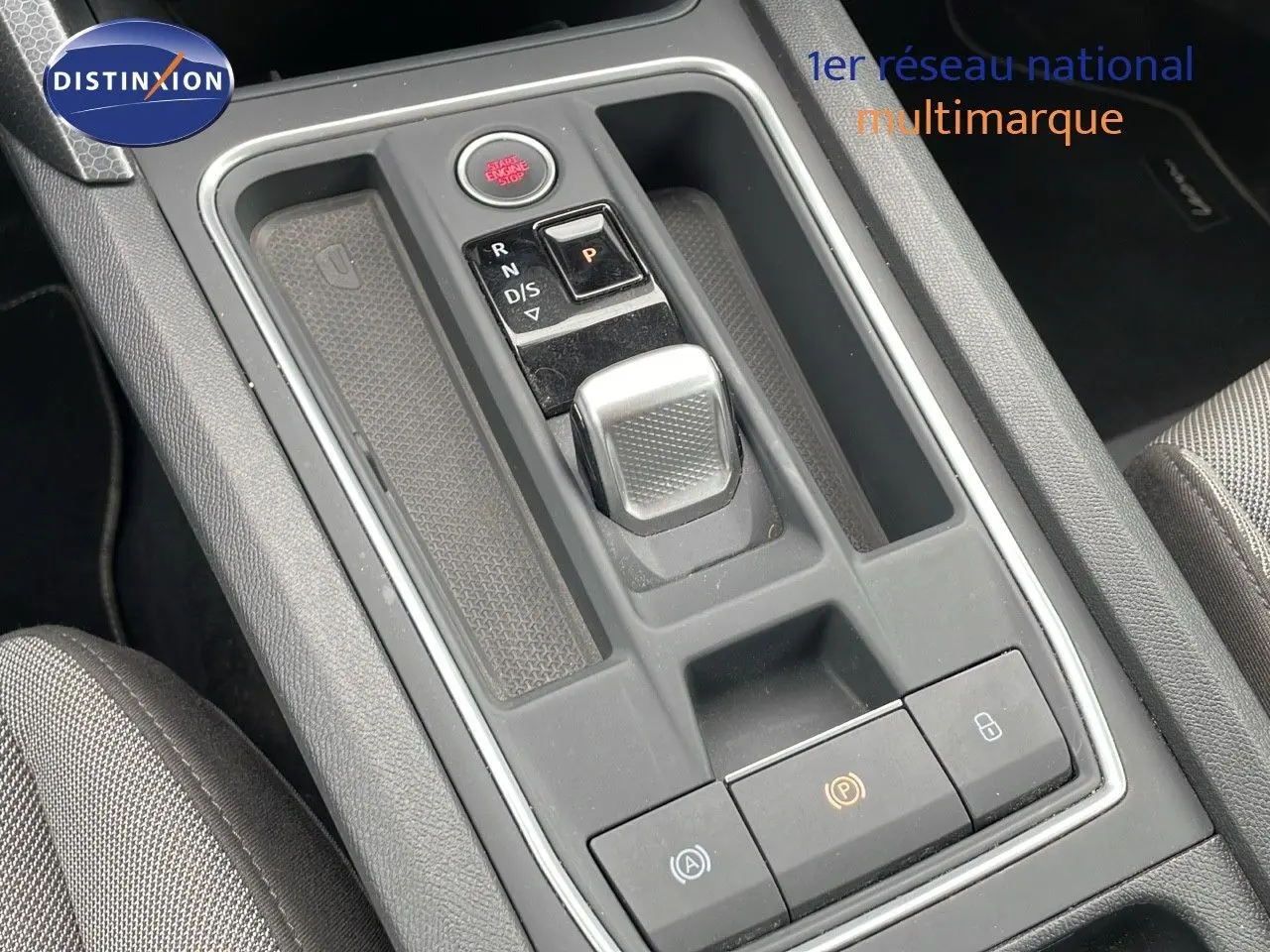 Gros plan sur la console centrale grise avec levier de boîte automatique et bouton start/stop d'une SEAT LEON ST 2023.