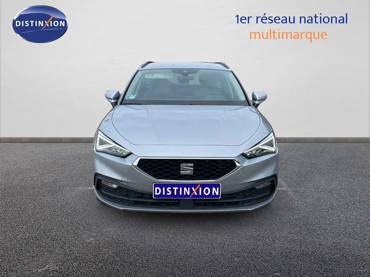 Vue frontale d'une SEAT LEON ST gris urbain 2023 avec calandre hexagonale et phares LED anguleux.