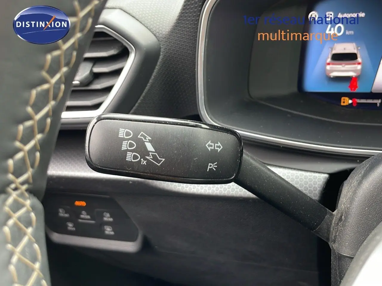 Le levier de clignotant noir avec pictogrammes, près du volant d'une SEAT Leon ST gris urbain 2023, intérieur moderne.