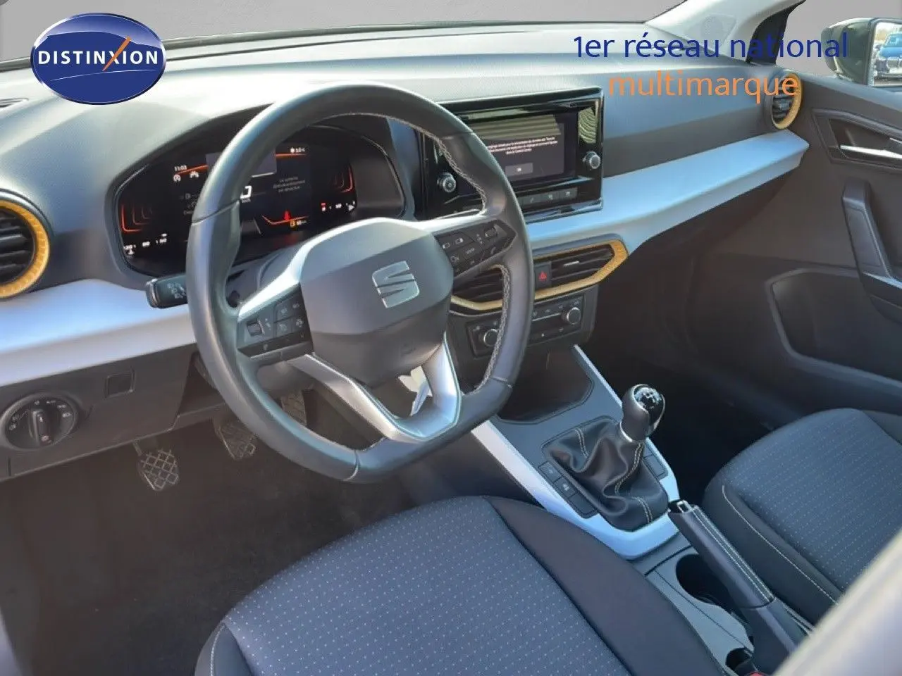 Vue intérieure côté conducteur du tableau de bord et volant du SEAT Arona gris magnétique avec boîte manuelle.