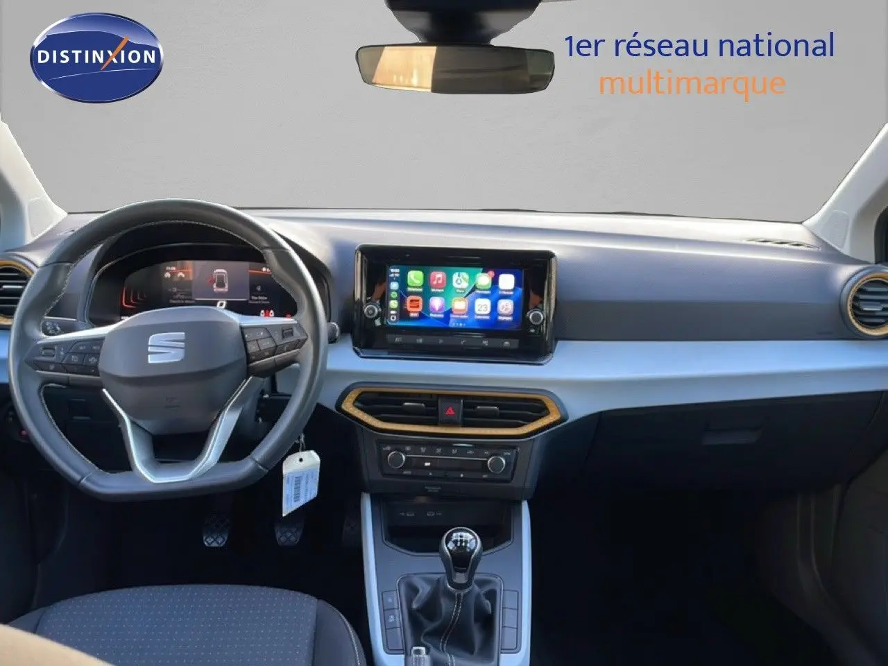 Vue intérieure frontale du tableau de bord du SEAT Arona gris magnétique, avec volant cuir multifonction et écran tactile central.