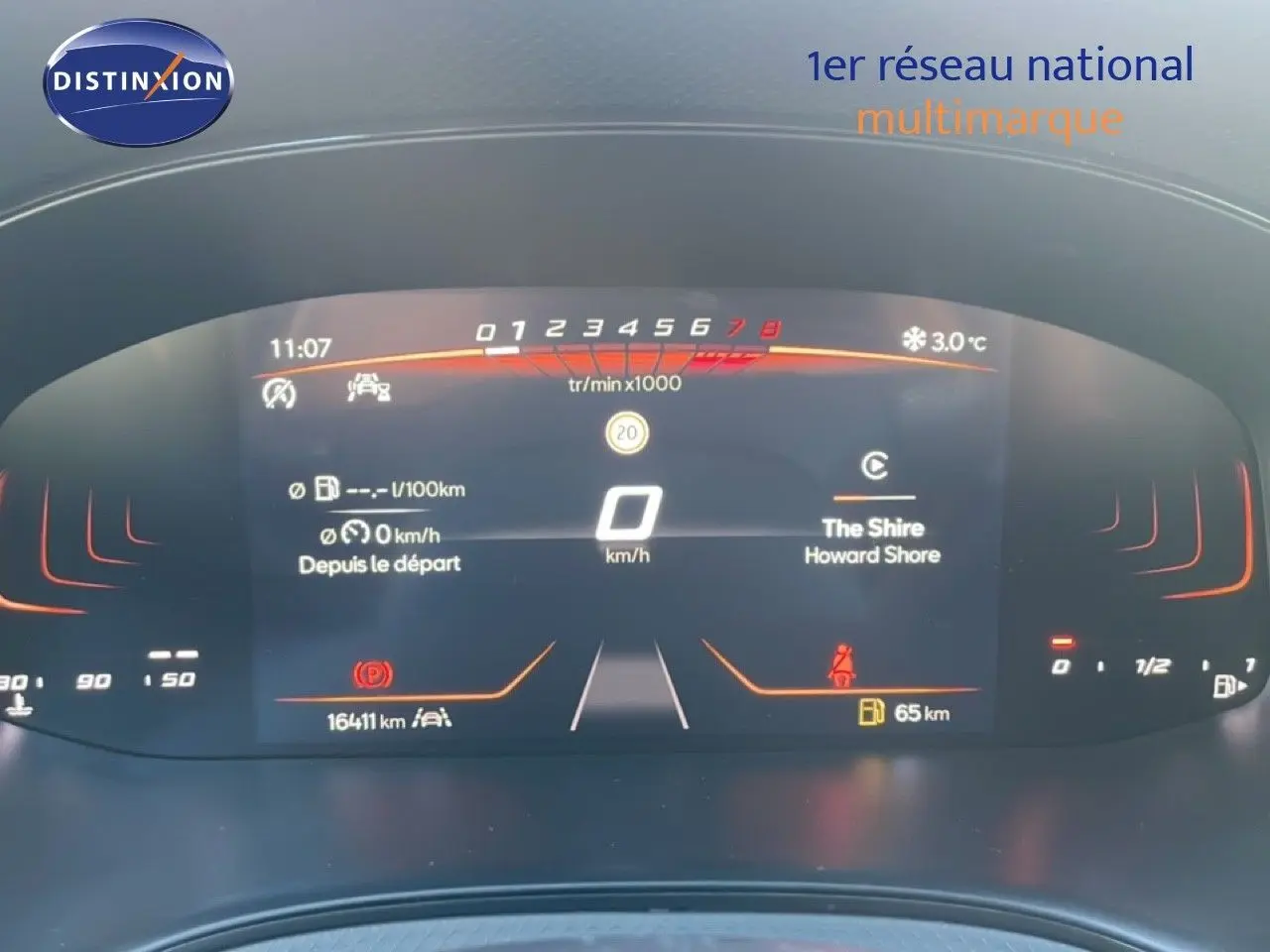 Vue de face du tableau de bord numérique du SEAT Arona gris magnétique, affichant la vitesse à 0 km/h et diverses informations.