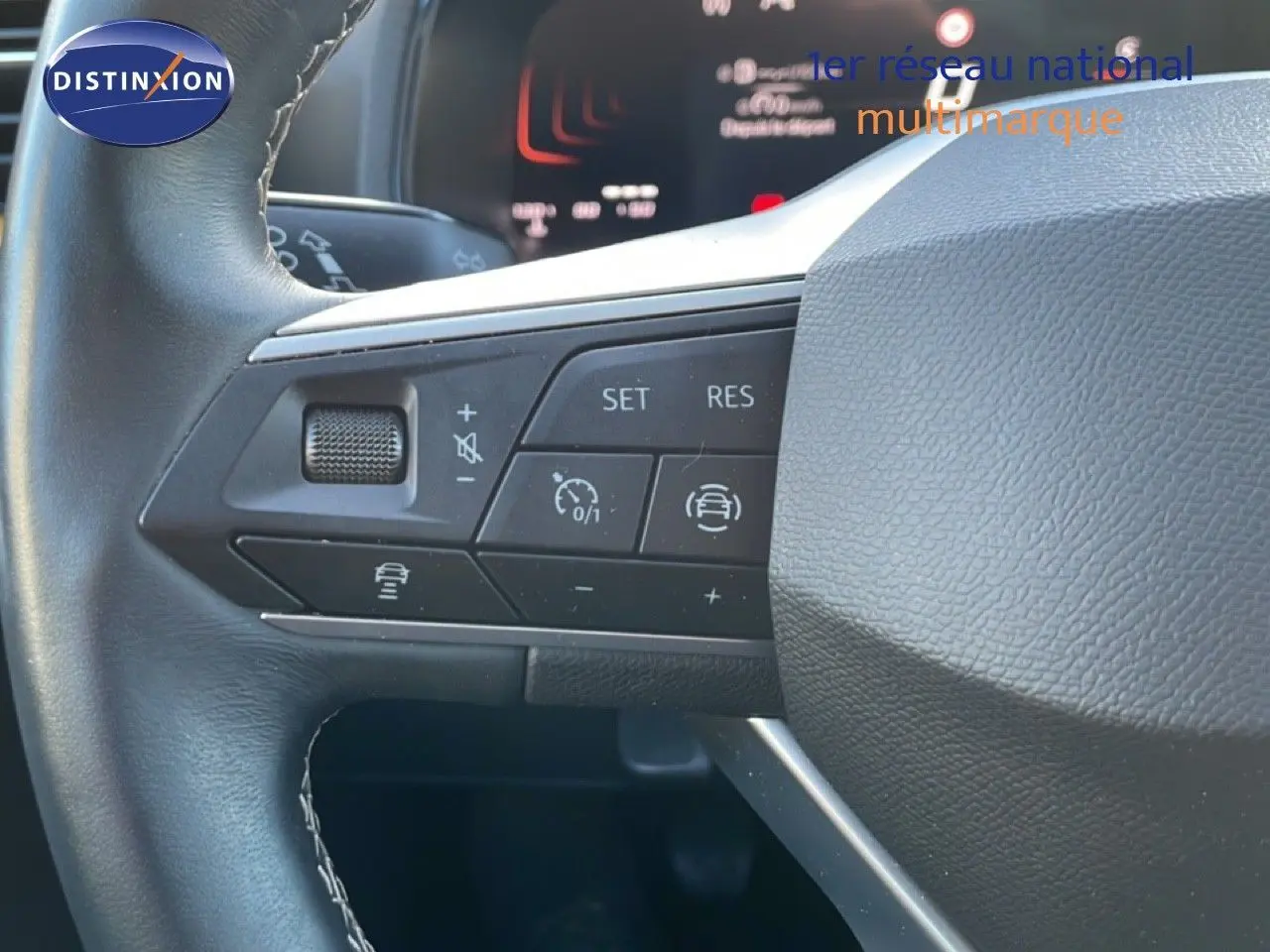 Gros plan sur les commandes au volant côté gauche du SEAT Arona 2025, volant cuir noir avec boutons multifonctions.