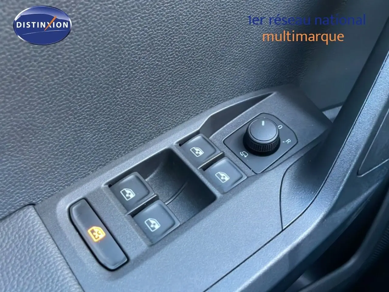 Gros plan sur les commandes des vitres électriques et des rétroviseurs côté conducteur d'une SEAT Arona gris magnétique.