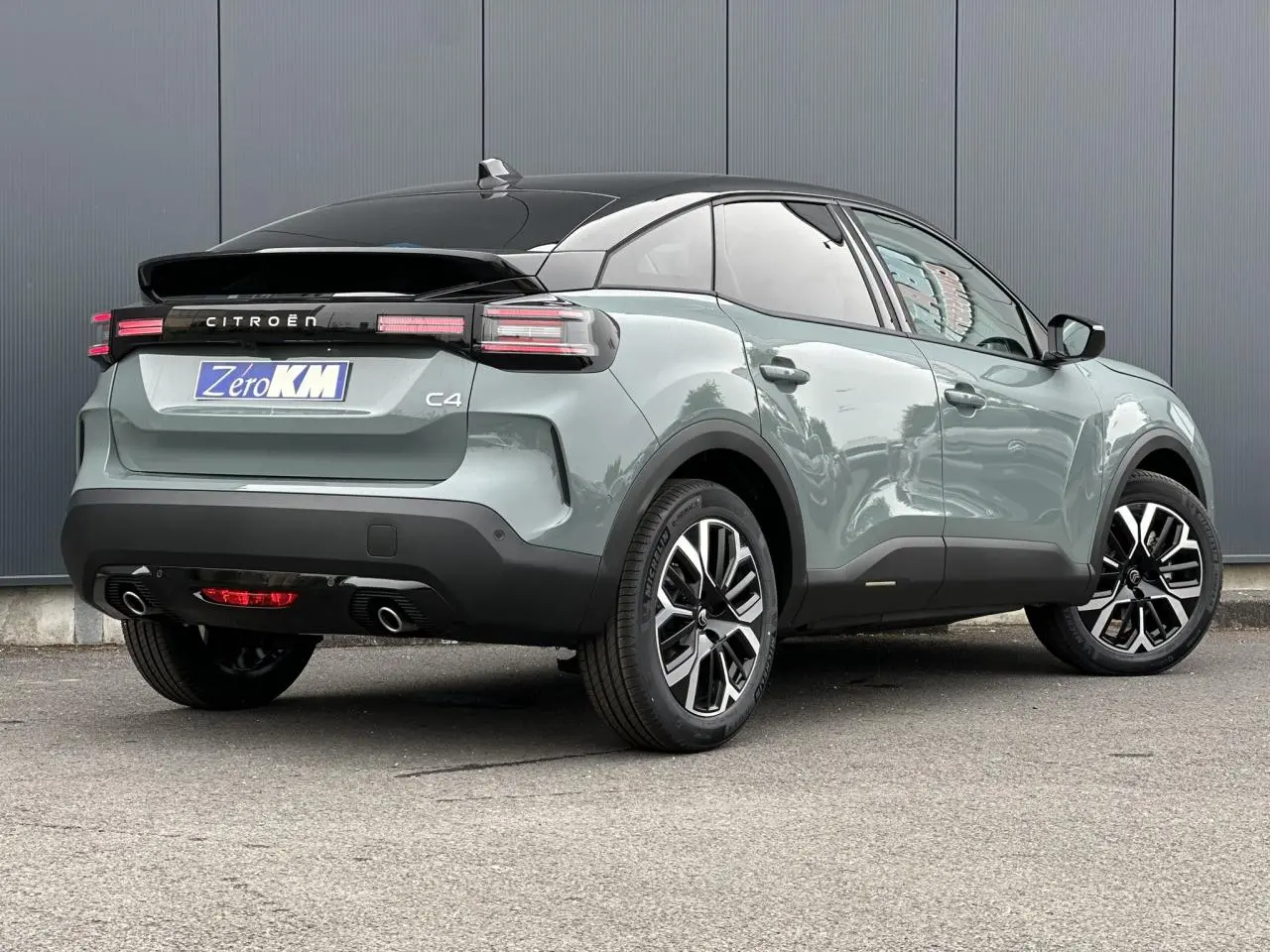 Vue 3/4 arrière droite d'une Citroën C4 Manhattan Green avec toit noir et jantes alliage 18 pouces.