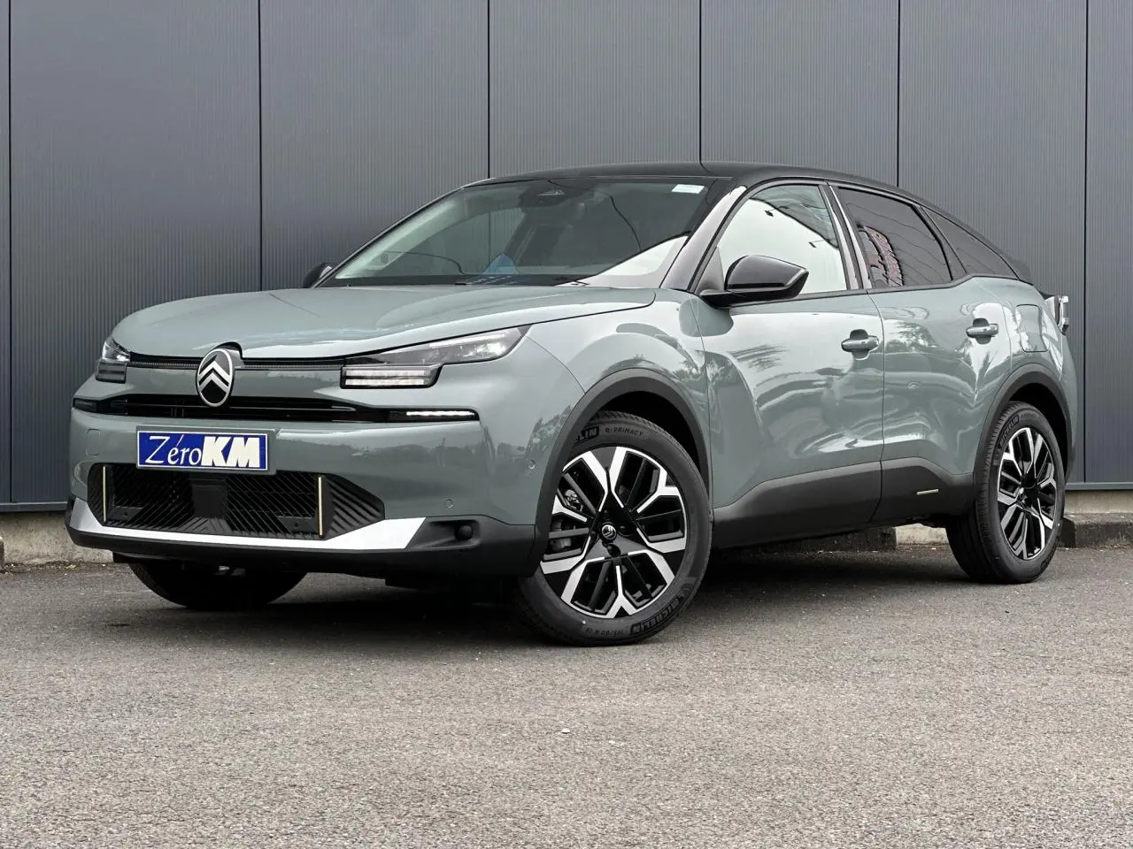 Citroën C4 2025 Manhattan Green vue 3/4 avant droit avec toit noir et jantes alliage 18 pouces.