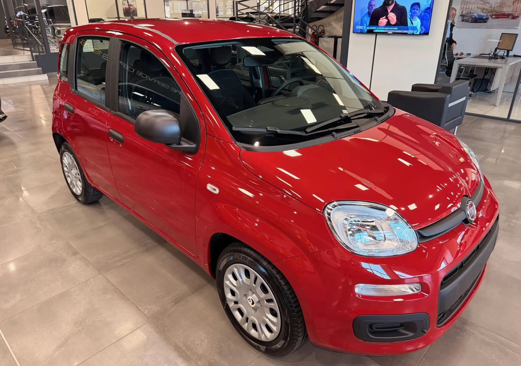 Vue 3/4 avant droite de la Fiat Panda 1.0 Hybrid 2025 en Rouge Amore, avec rétroviseurs noirs et jantes acier.