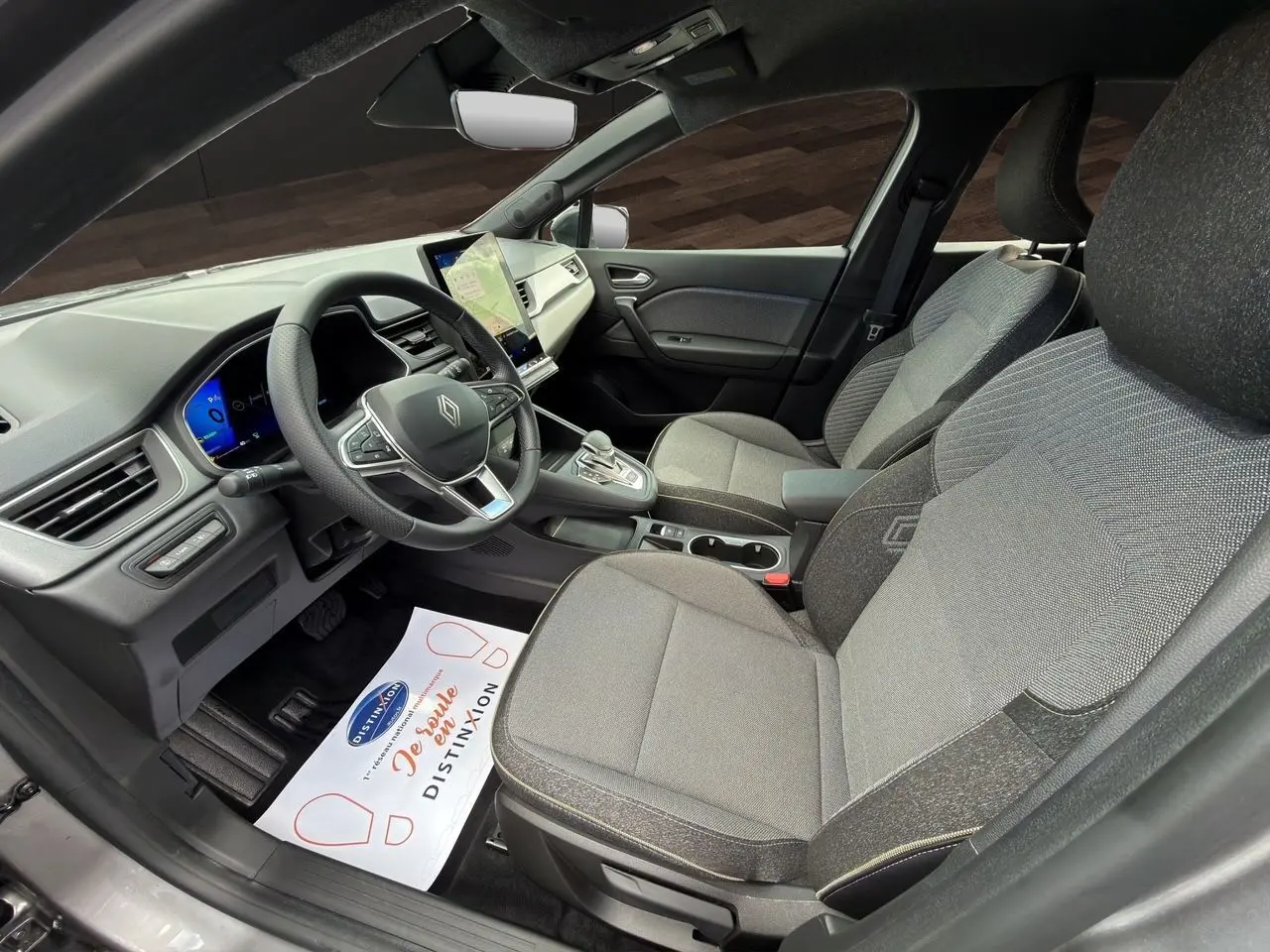 Vue intérieure côté conducteur de la Renault SYMBIOZ gris clair, avec tableau de bord digital et sièges tissu gris.