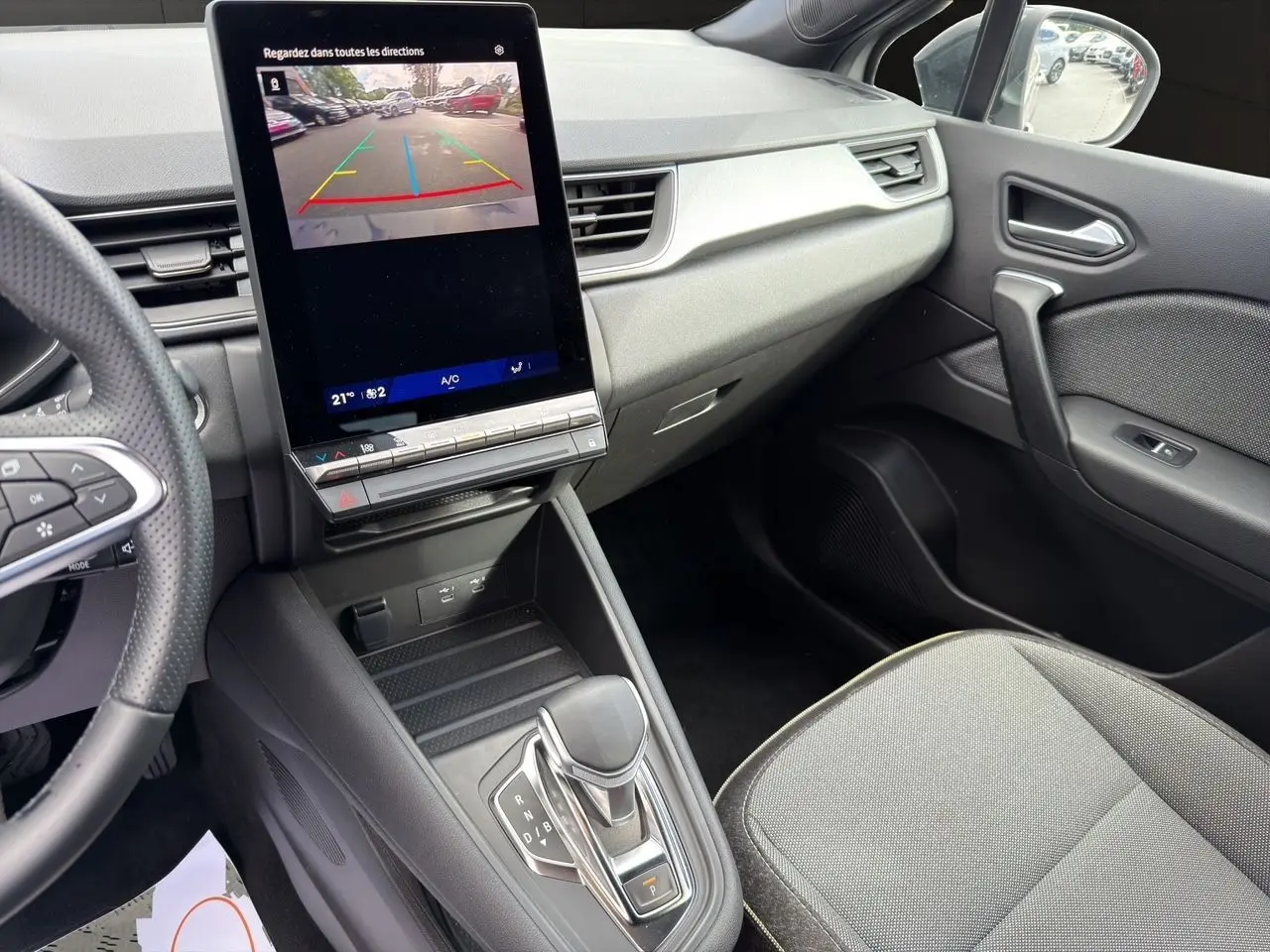 Vue intérieure côté passager du Renault Symbioz gris clair 2025, avec écran tactile central affichant la caméra de recul.