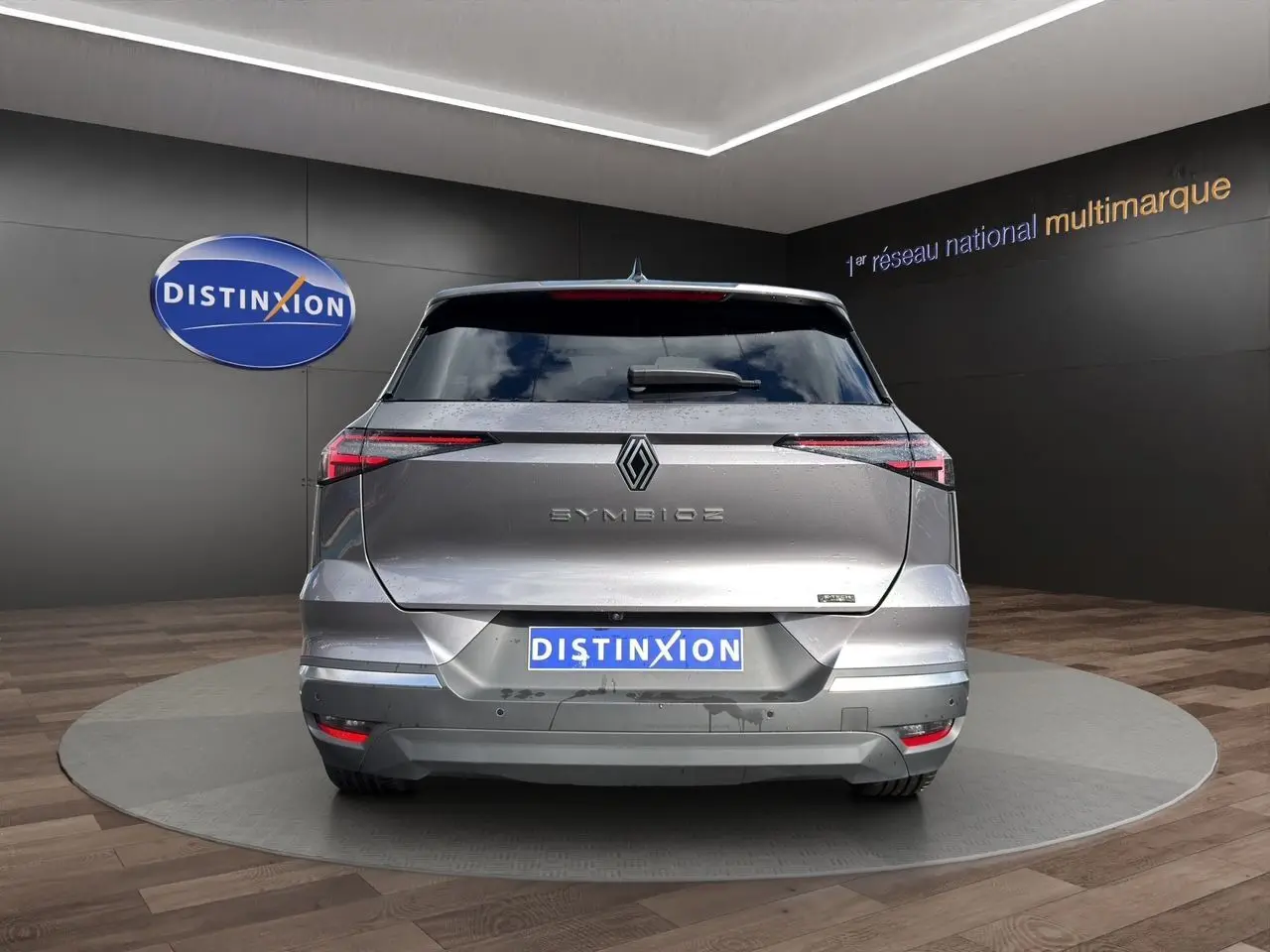 Vue arrière d'une Renault Symbioz gris clair 2025 avec feux LED fins et logo central distinctif.