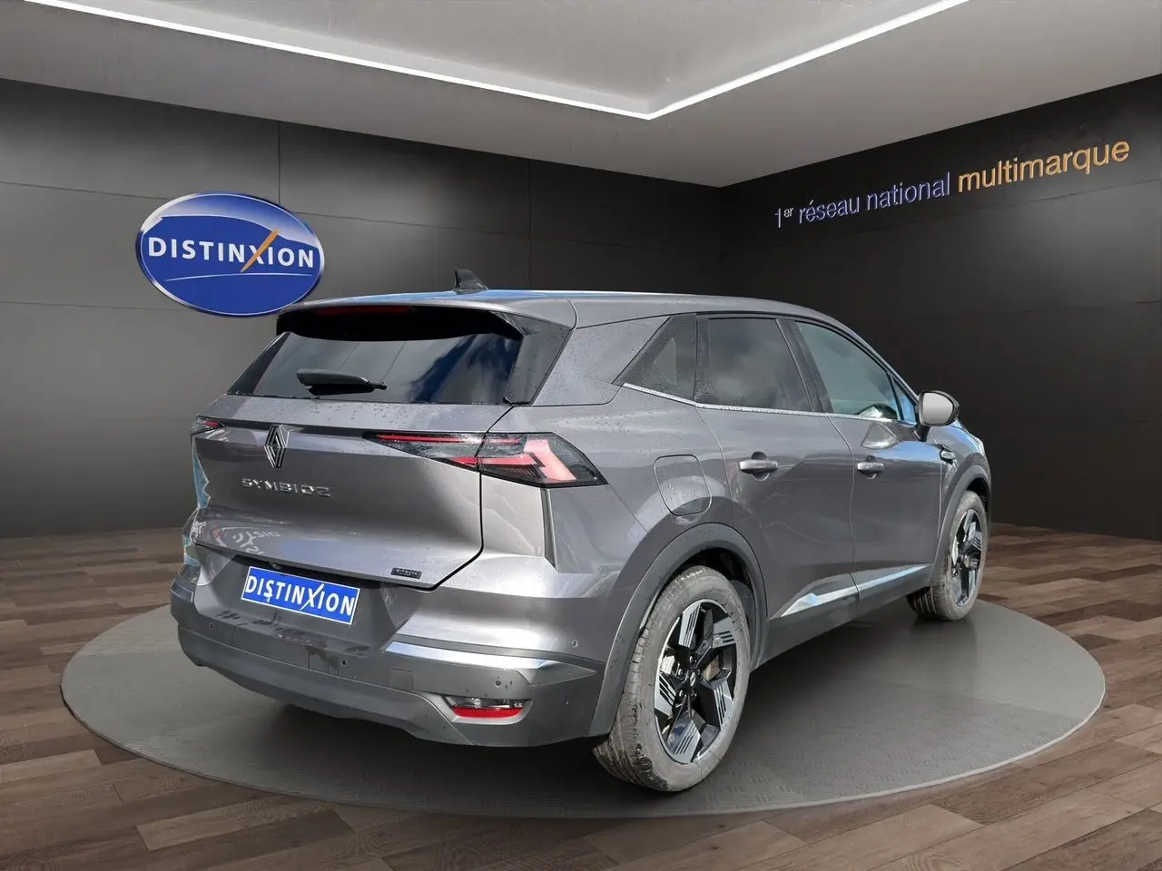 Renault SYMBIOZ gris clair en 3/4 arrière droit, avec feux arrière LED fins et jantes noires distinctives.