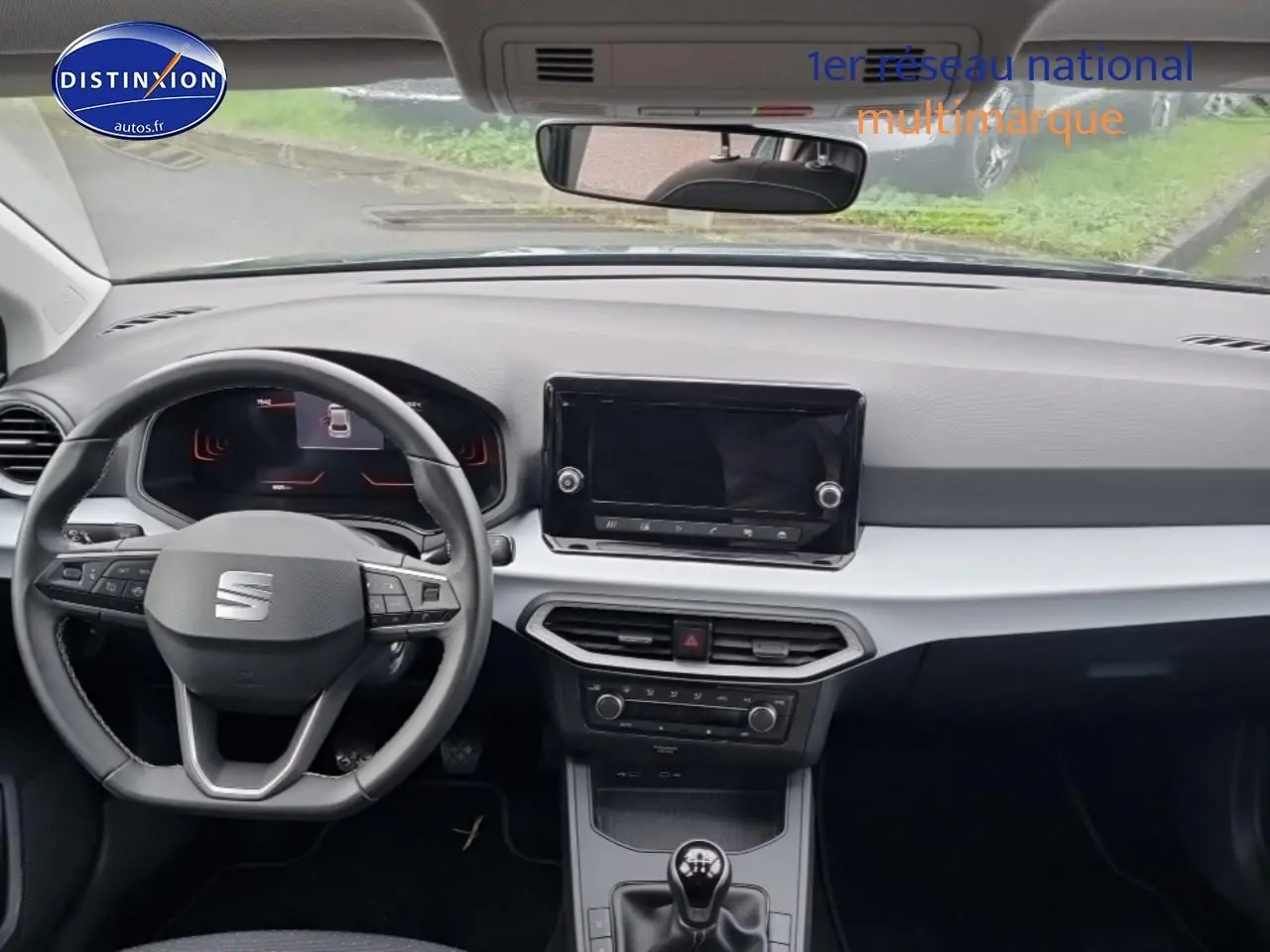 Vue intérieure frontale du tableau de bord gris clair et noir de la SEAT Ibiza 1.0 TSI 95 Copa avec volant multifonction et écran tactile.
