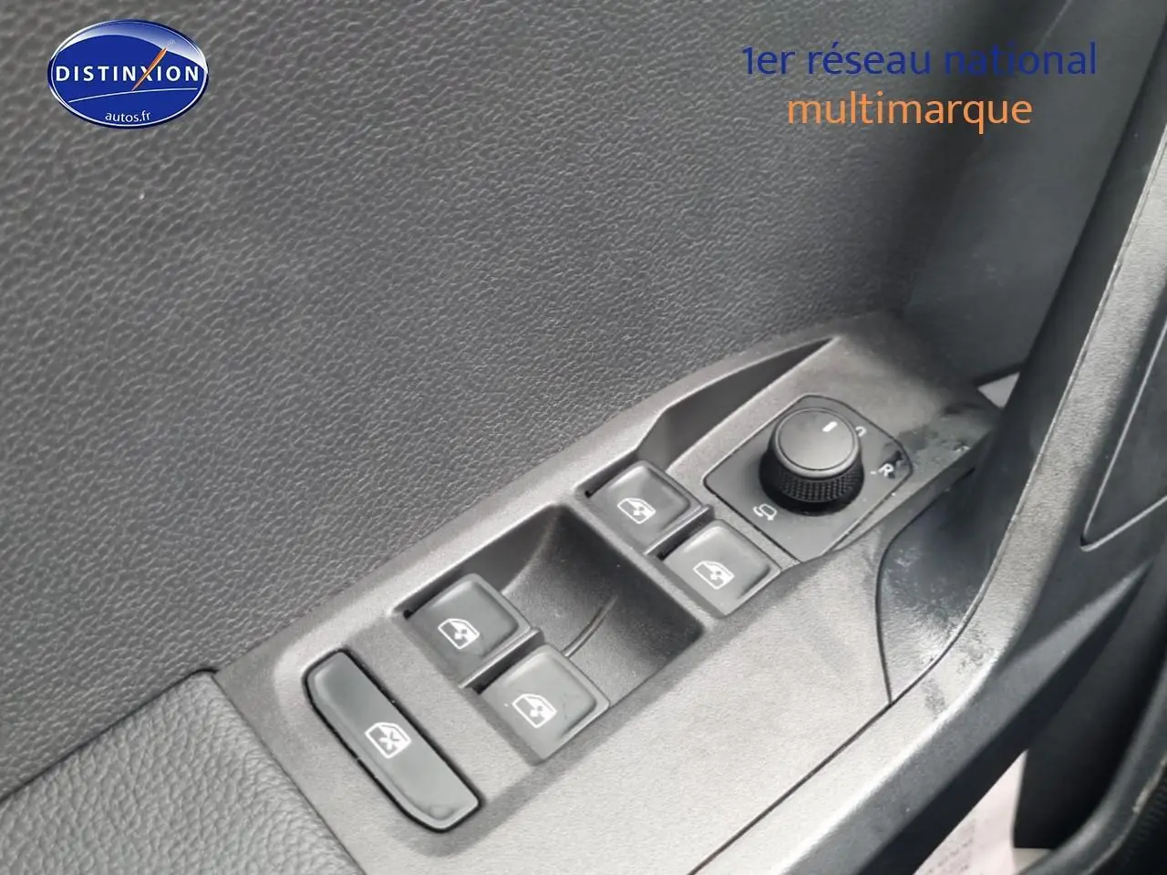 Détail des commandes des vitres électriques et réglage des rétroviseurs sur la porte côté conducteur d'une SEAT Ibiza gris 2025.