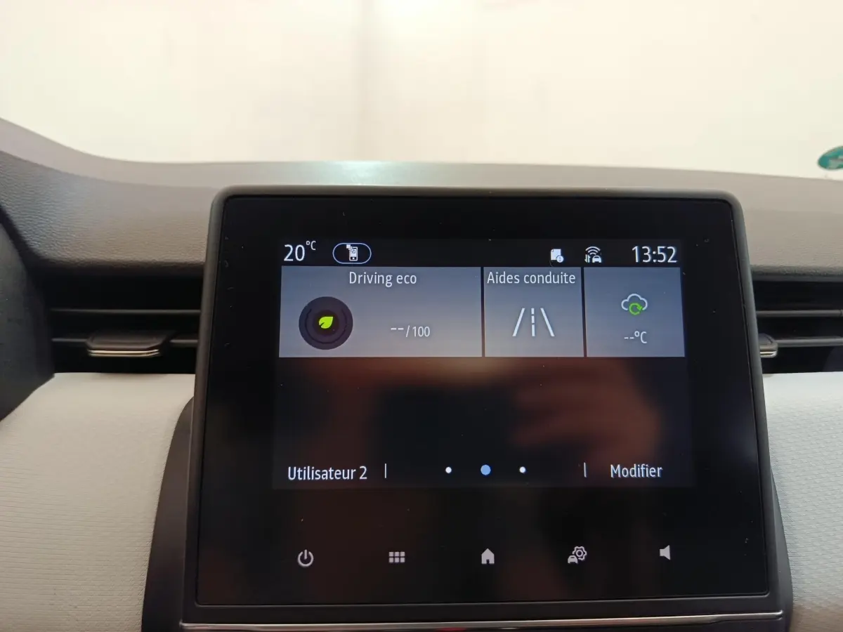 Écran tactile central de la Renault Clio blanc 2023 affichant les aides à la conduite et la température intérieure.