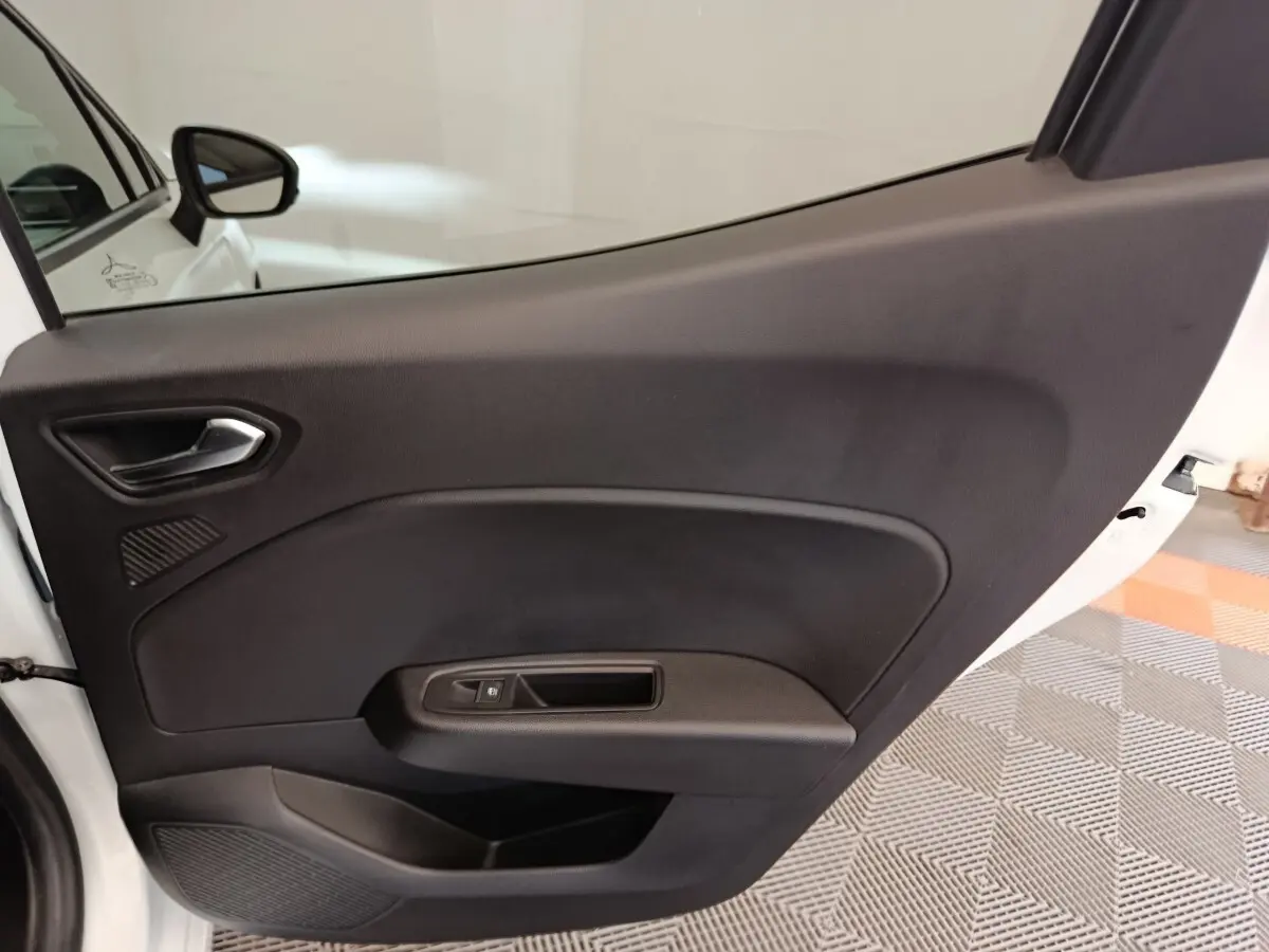 Vue rapprochée de la porte arrière droite noire intérieure de la Renault Clio blanche Evolution TCe 100 GPL 2023.