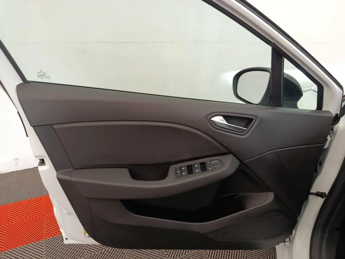Vue intérieure de la porte avant gauche blanche de la Renault Clio Evolution TCe 100 GPL avec commandes électriques.