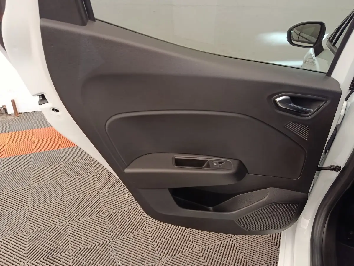 Vue intérieure de la porte arrière droite noire d'une Renault Clio blanche Evolution TCe 100 GPL 2023.