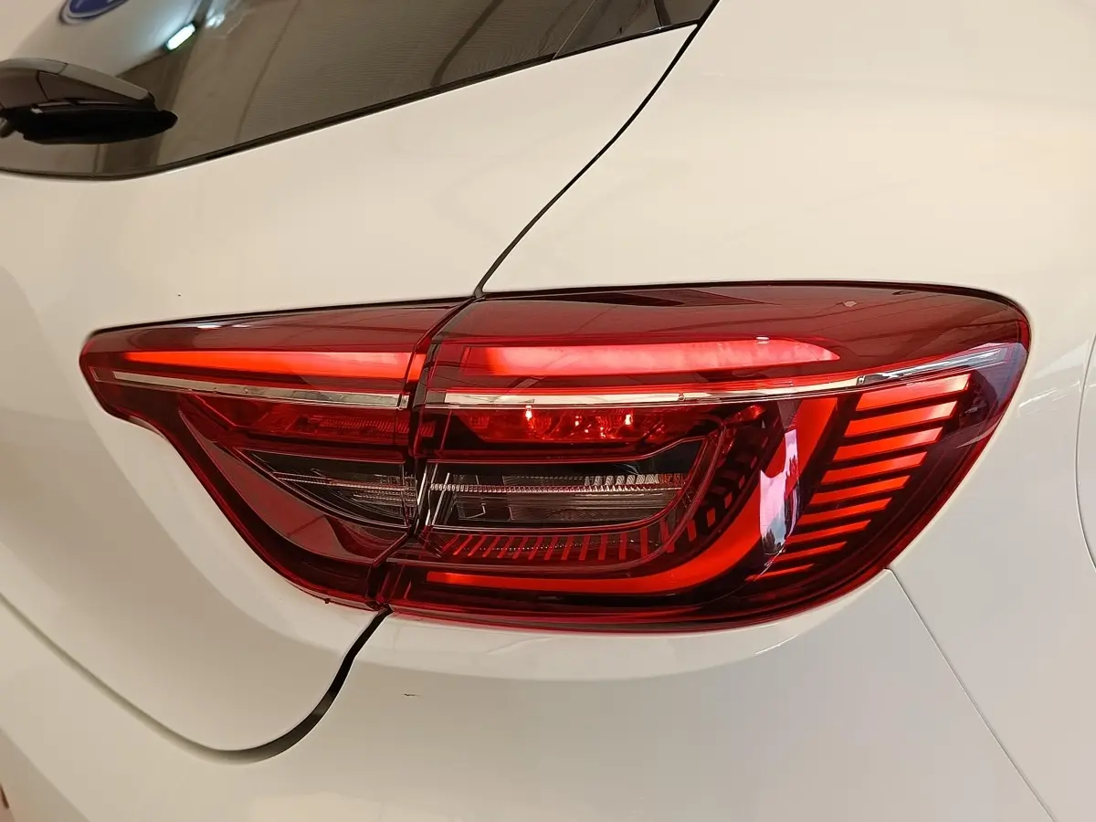 Gros plan sur le feu arrière droit rouge de la Renault Clio blanche Evolution TCe 100 GPL 2023.
