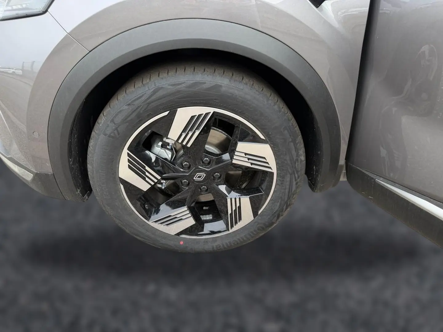 Gros plan sur la roue avant gauche du Renault Symbioz gris cassiopée avec jante alu noire et argentée au design géométrique.