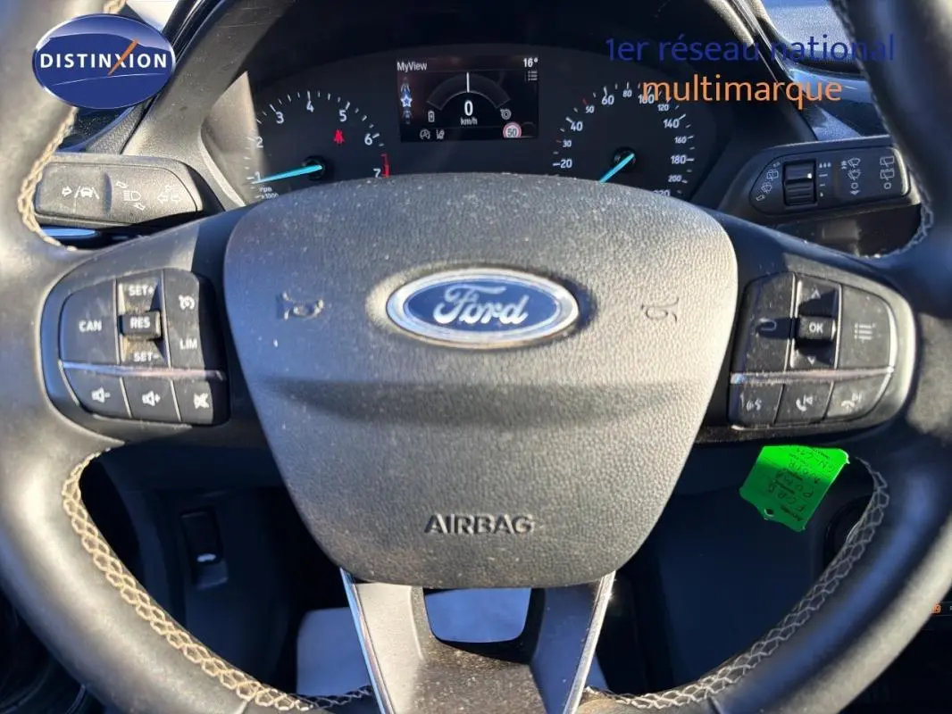 Vue rapprochée du volant noir de la Ford Puma 2023 avec commandes intégrées et tableau de bord digital.