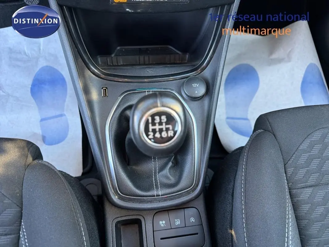 Vue rapprochée de la boîte manuelle noire et des sièges sport en tissu gris foncé dans un Ford Puma noir 2023.