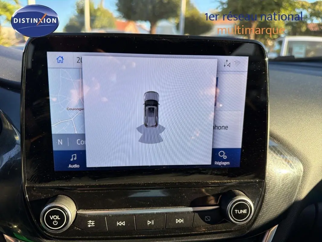 Écran tactile central du tableau de bord du Ford Puma 2023 noir, affichant la navigation et l'aide au stationnement.